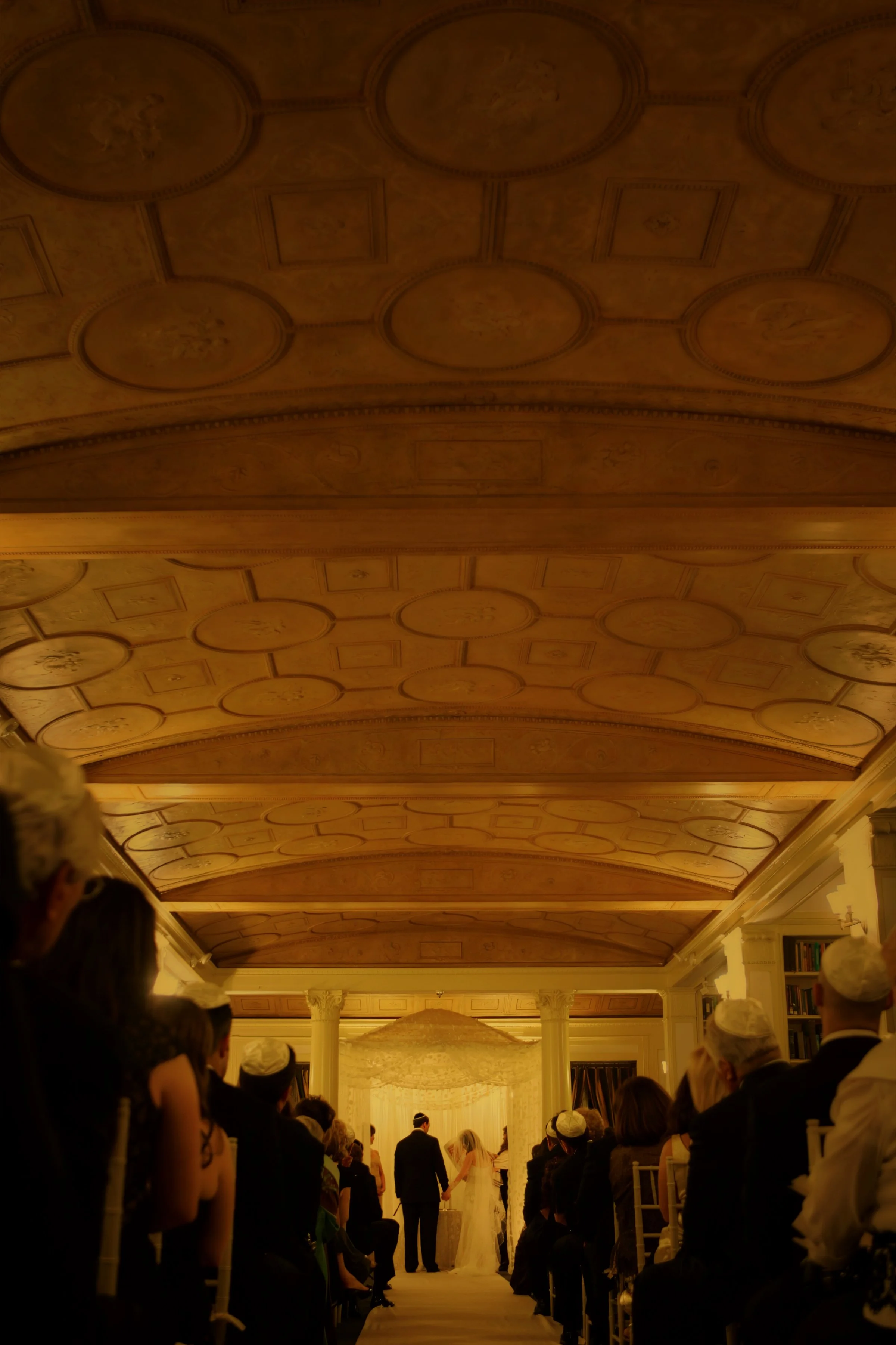 Sweeping view of the wedding ceremony highlighting Yale Club ceilings