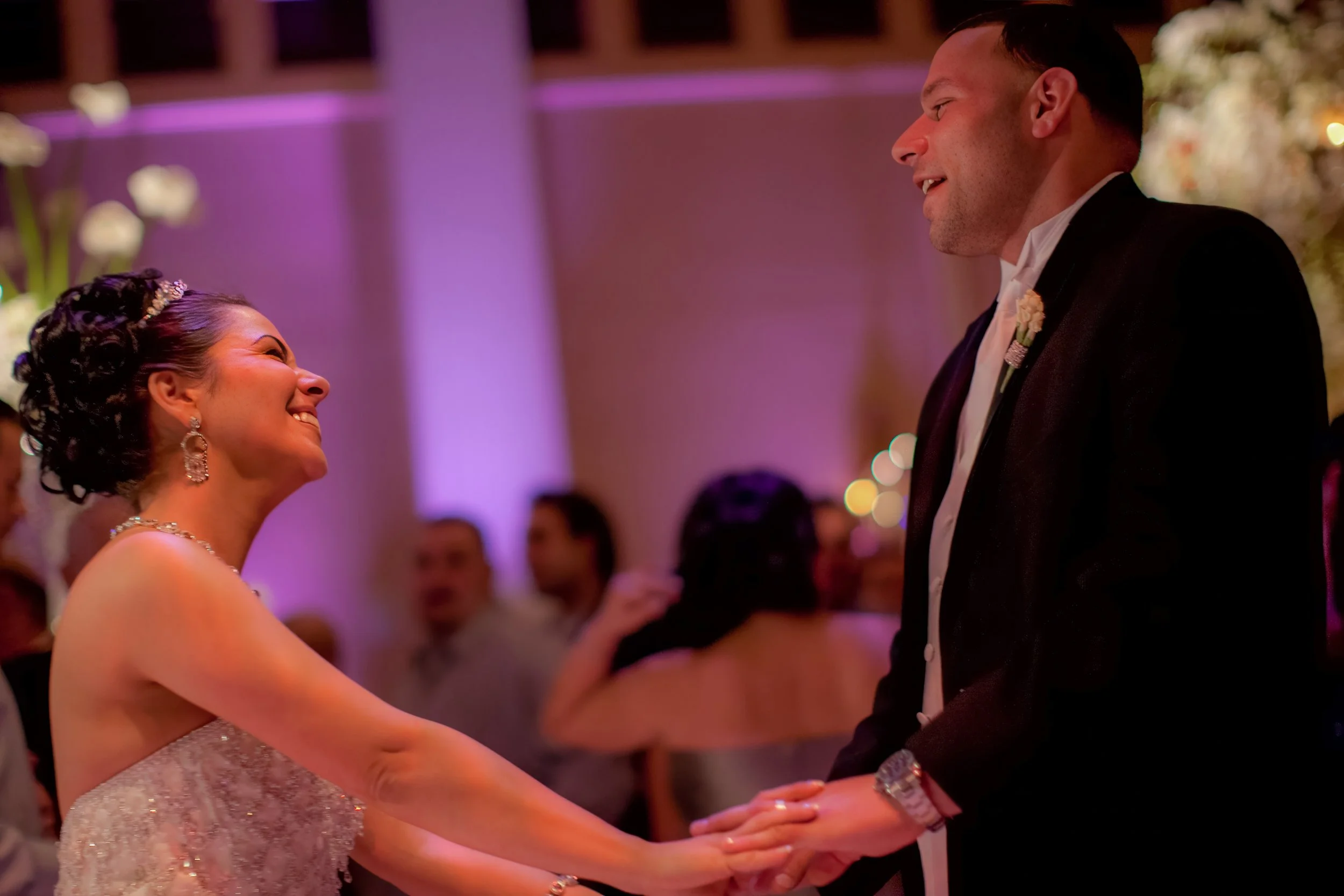 Candid moment of bride and groom sharing a first dance, filled with laughter and connection.