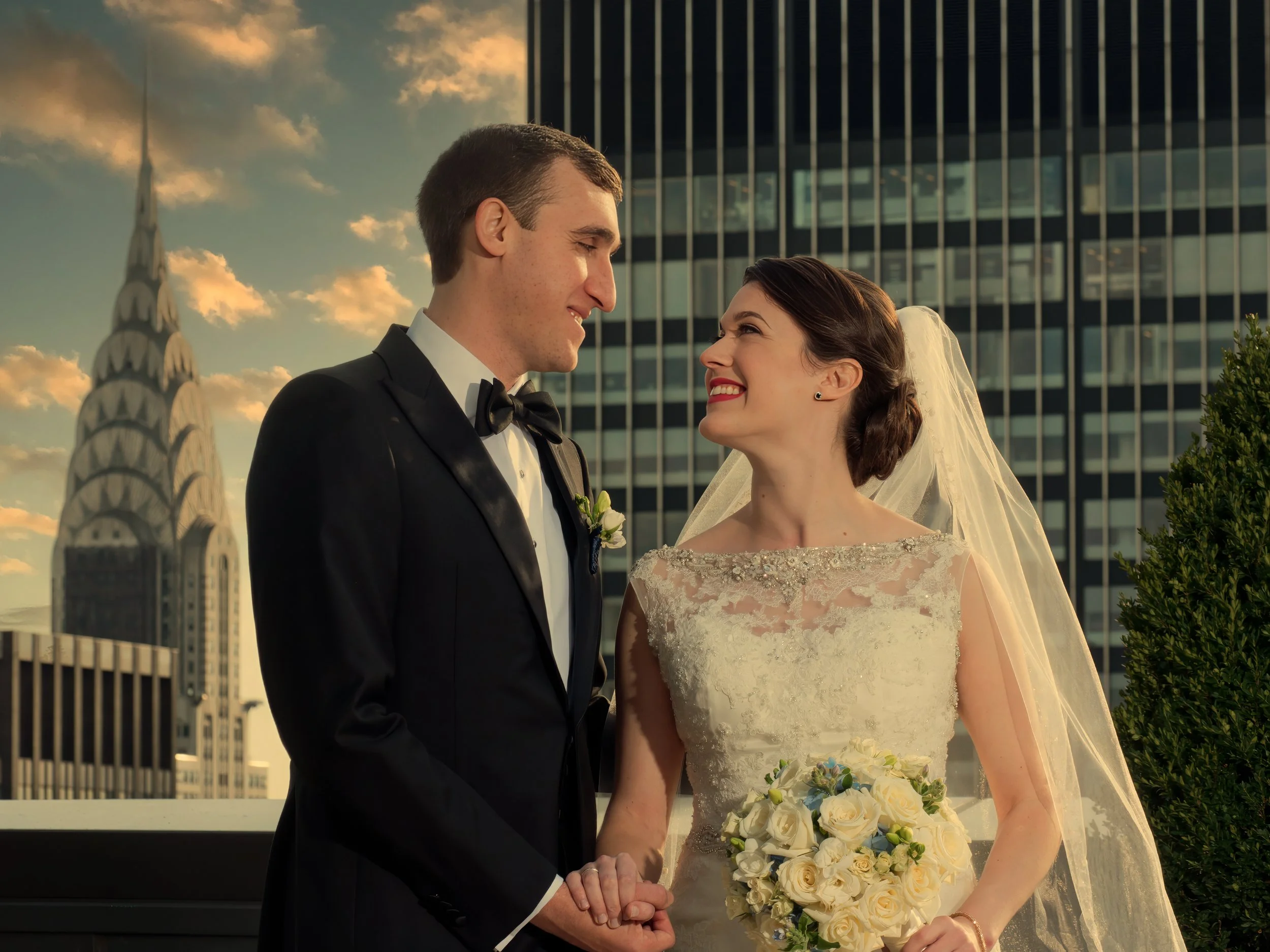 Bride and groom portrait on the rooftop of the Lotte New York Palace with the Chrysler Building rising above the Manhattan skyline.