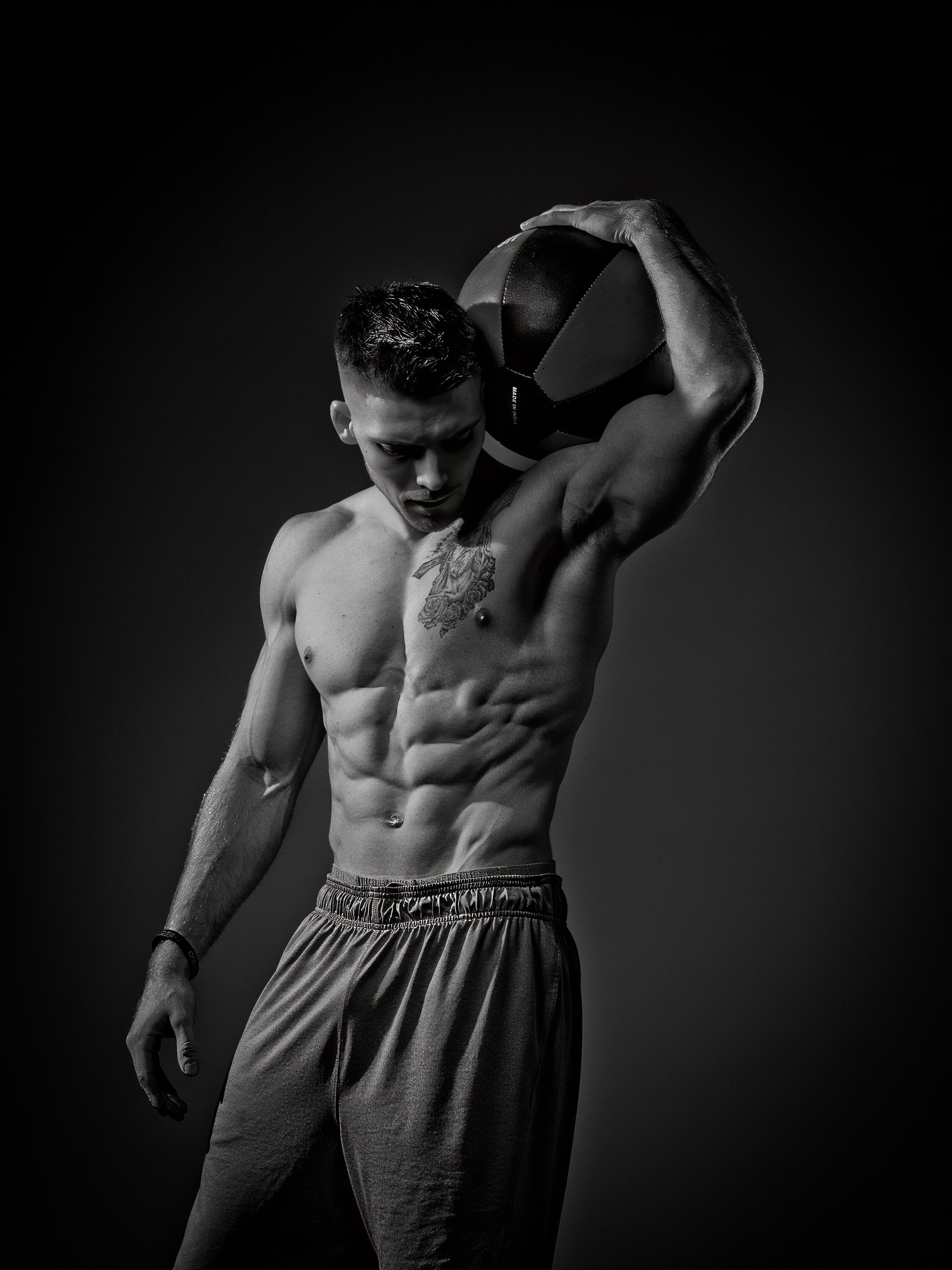 Chiseled athlete posing to showcase muscular physique during fashion photography session