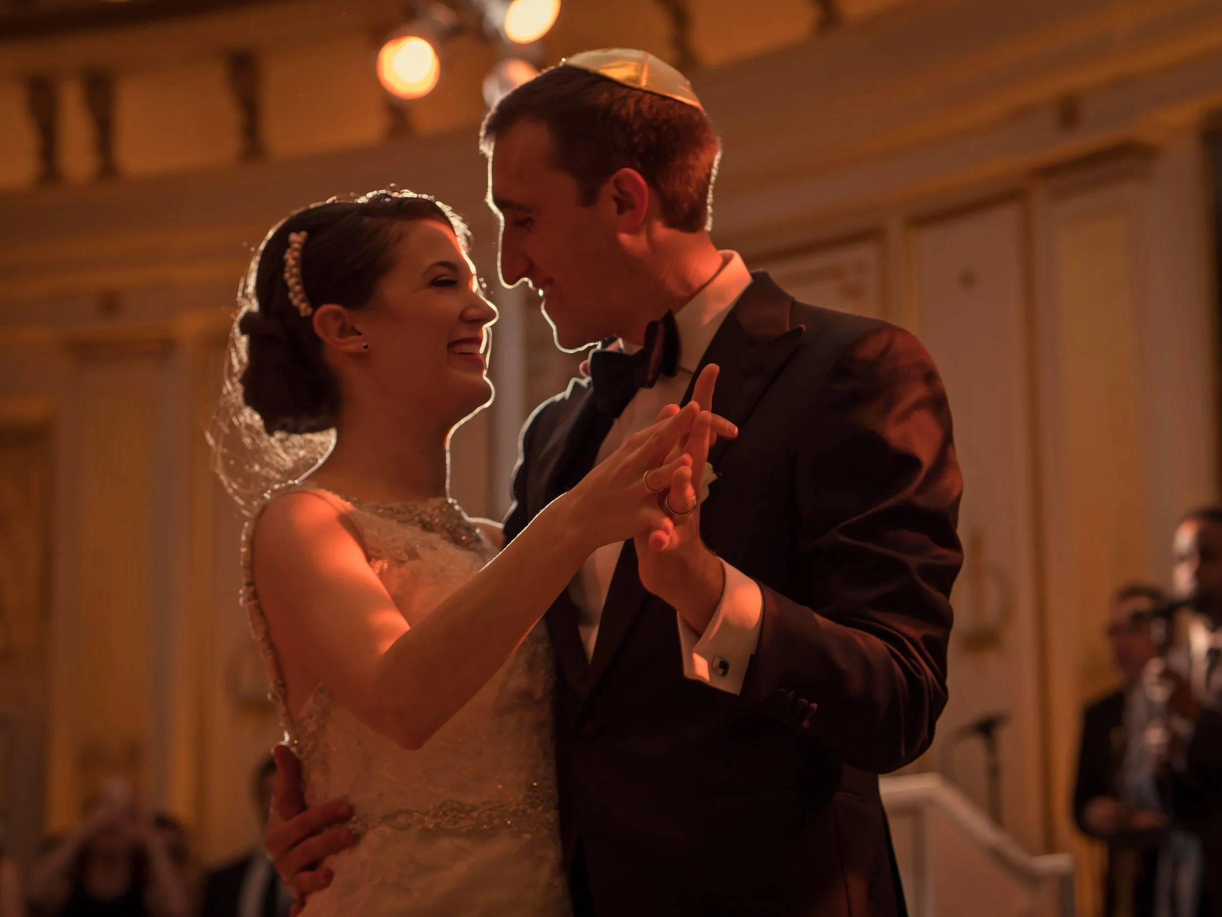 Closeup of a bride and groom during their first dance with rim lighting in the ballroom of the Lotte New York Palace.