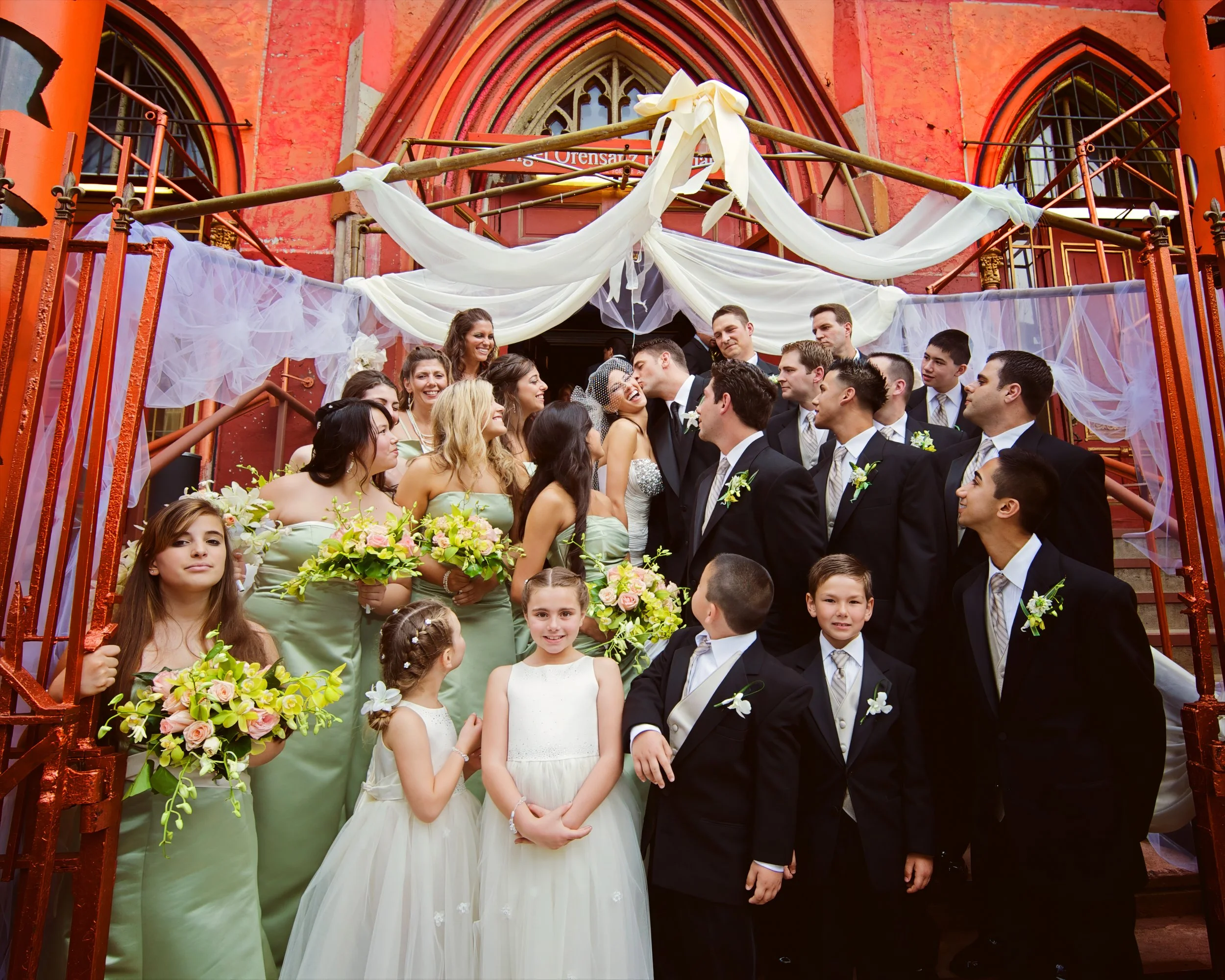 Playful wedding party celebrating on the steps outside Angel Orensanz on the Lower East Side.
