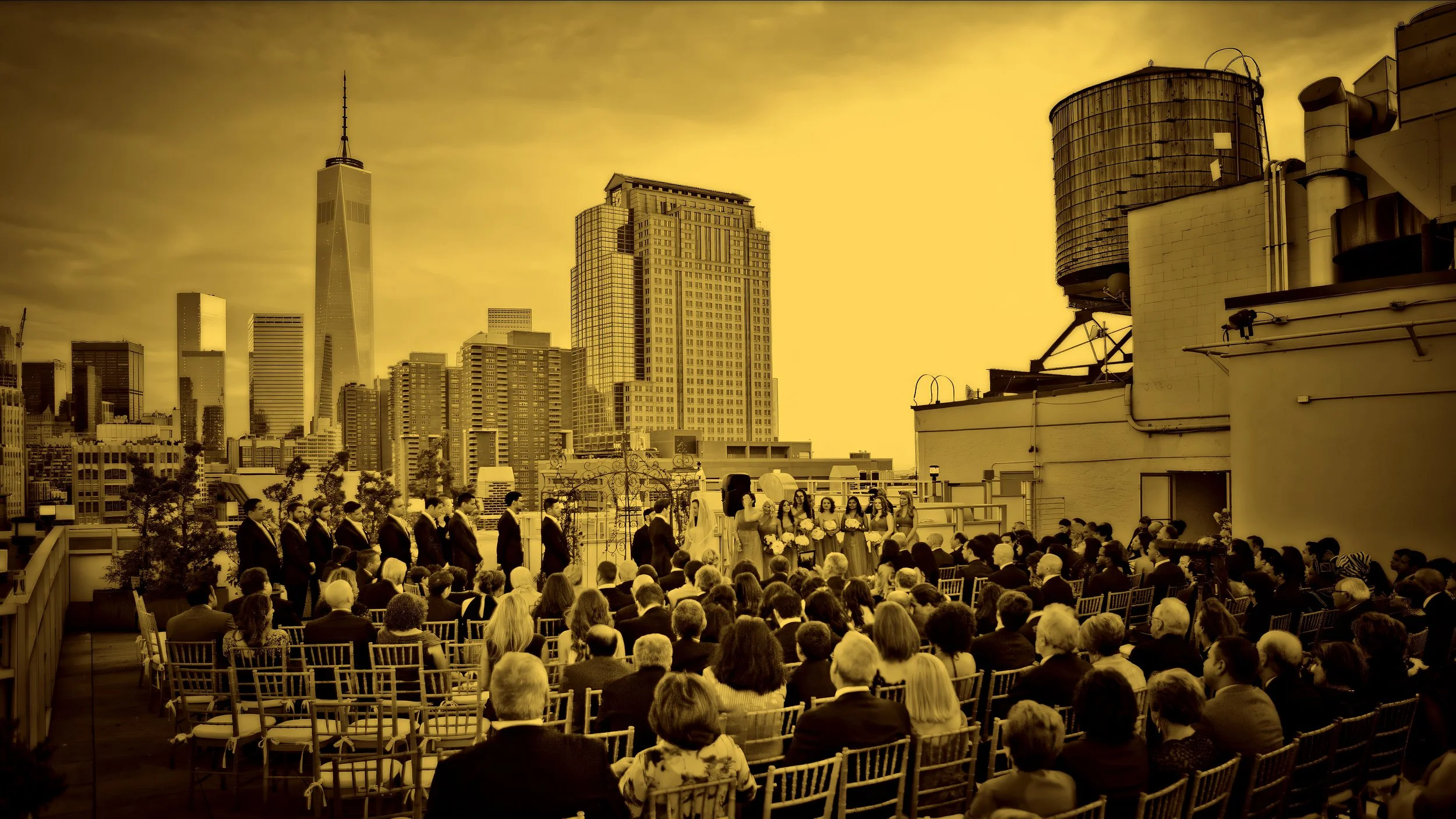 Wedding ceremony on the terrace of Tribeca Rooftop in NYC with sweeping Lower Manhattan skyline views in the background.