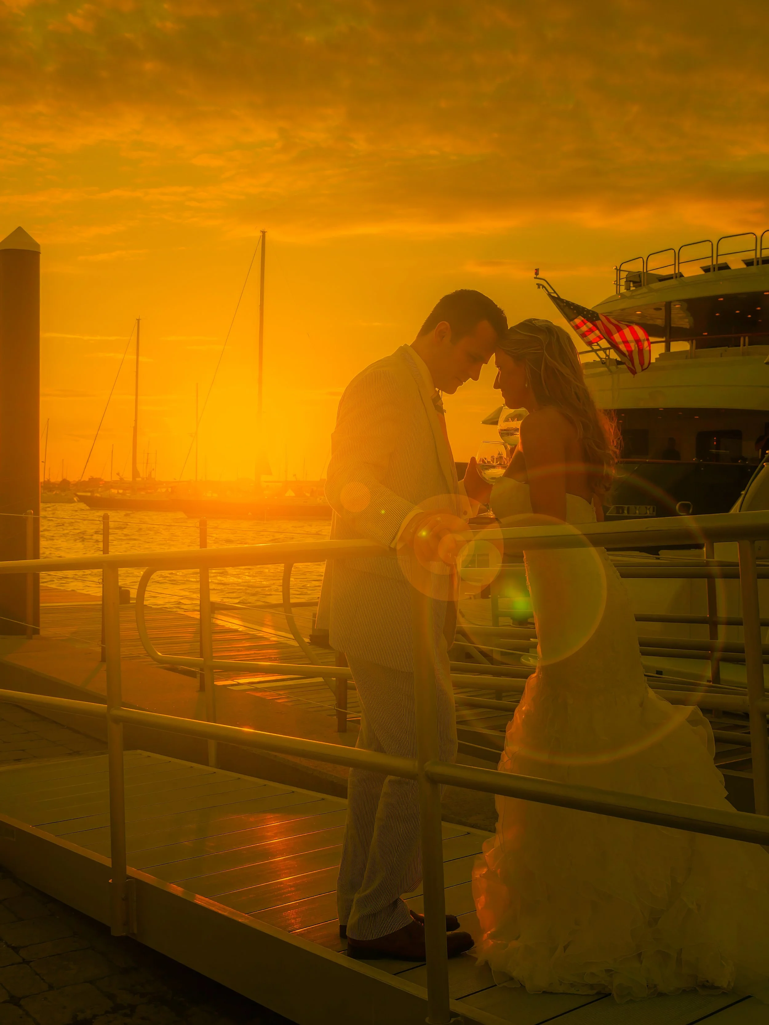 Sunset flares illuminate a bride and groom basking in golden sunlight at Newport Yachting Center.