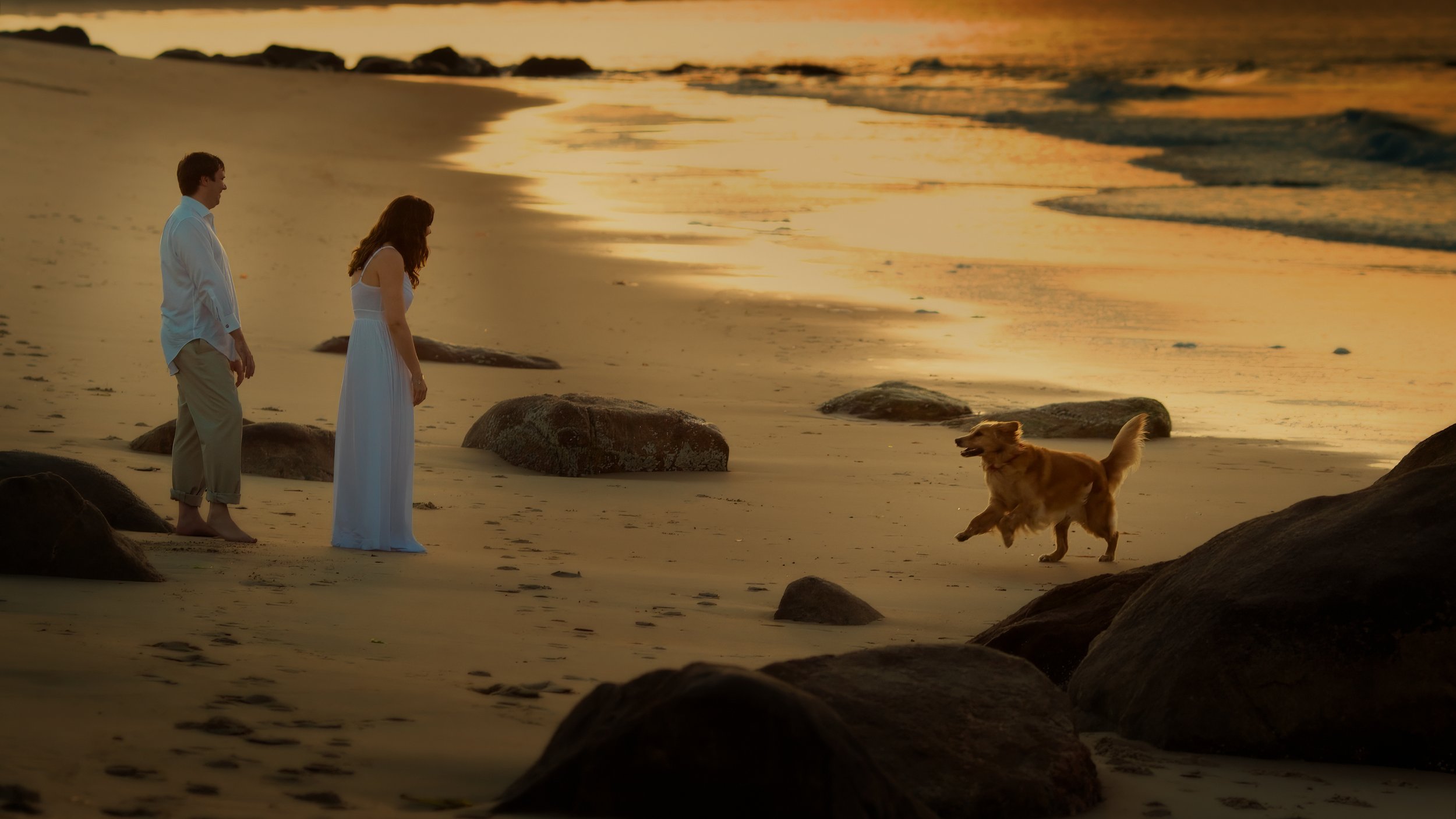 Couple enjoying engagement session on a Rhode Island beach with their dog