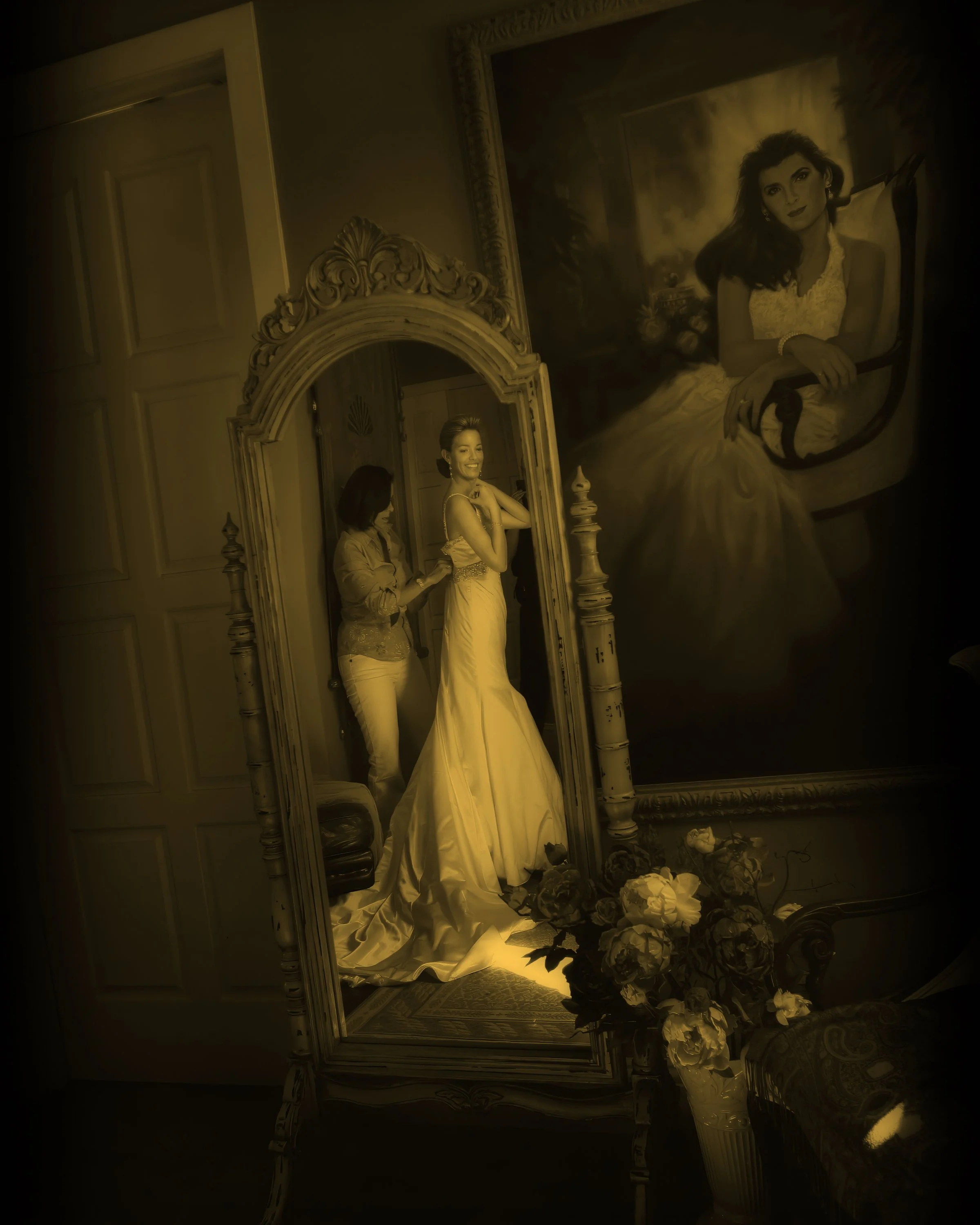 Bride putting on her wedding dress in front of a mirror at a private estate wedding in Sarasota, Florida.