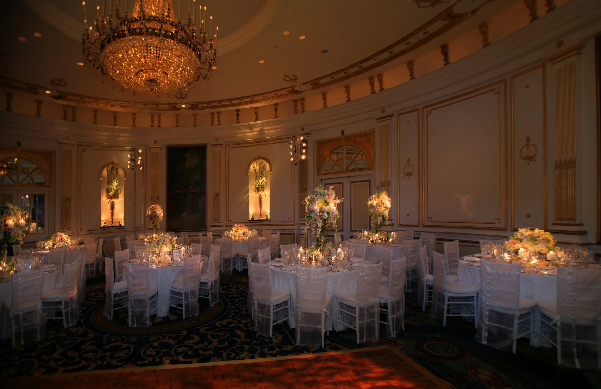 Wide angle view of elegant ballroom decor prepared for a wedding reception at the Lotte New York Palace Hotel.