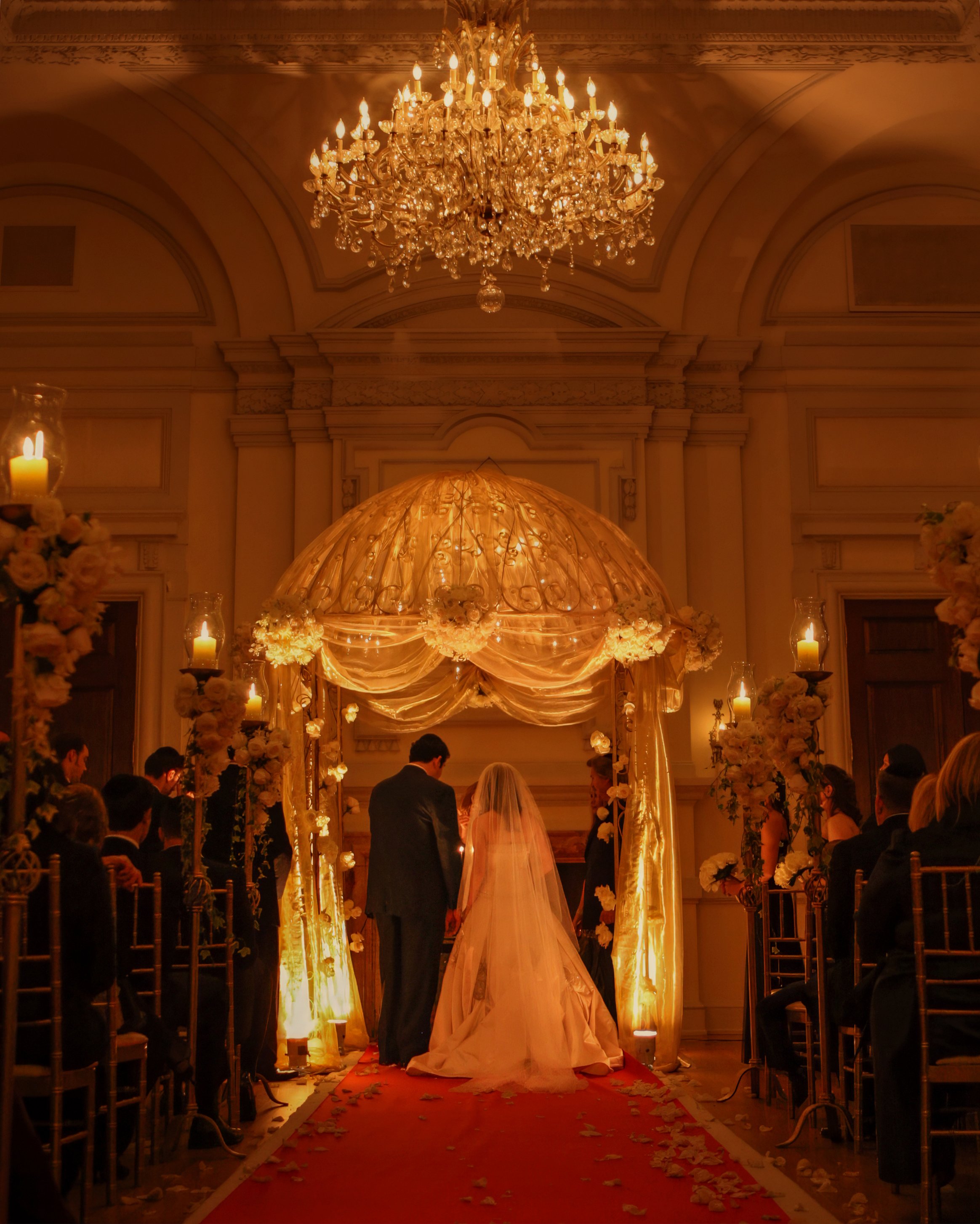 Bride and groom praying beneath the chuppah during a Jewish wedding ceremony at Oheka Castle on Long Island near New York City.