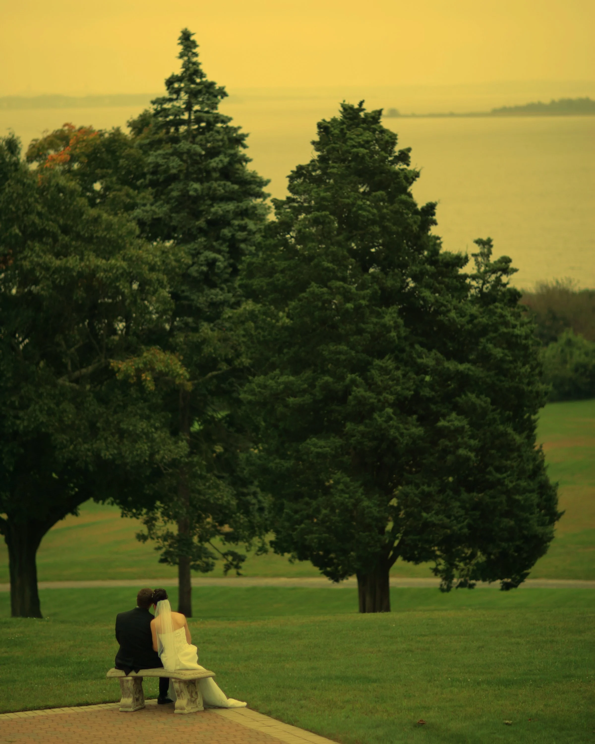 Bride and groom sharing a quiet moment together on a bench away from the wedding celebration.