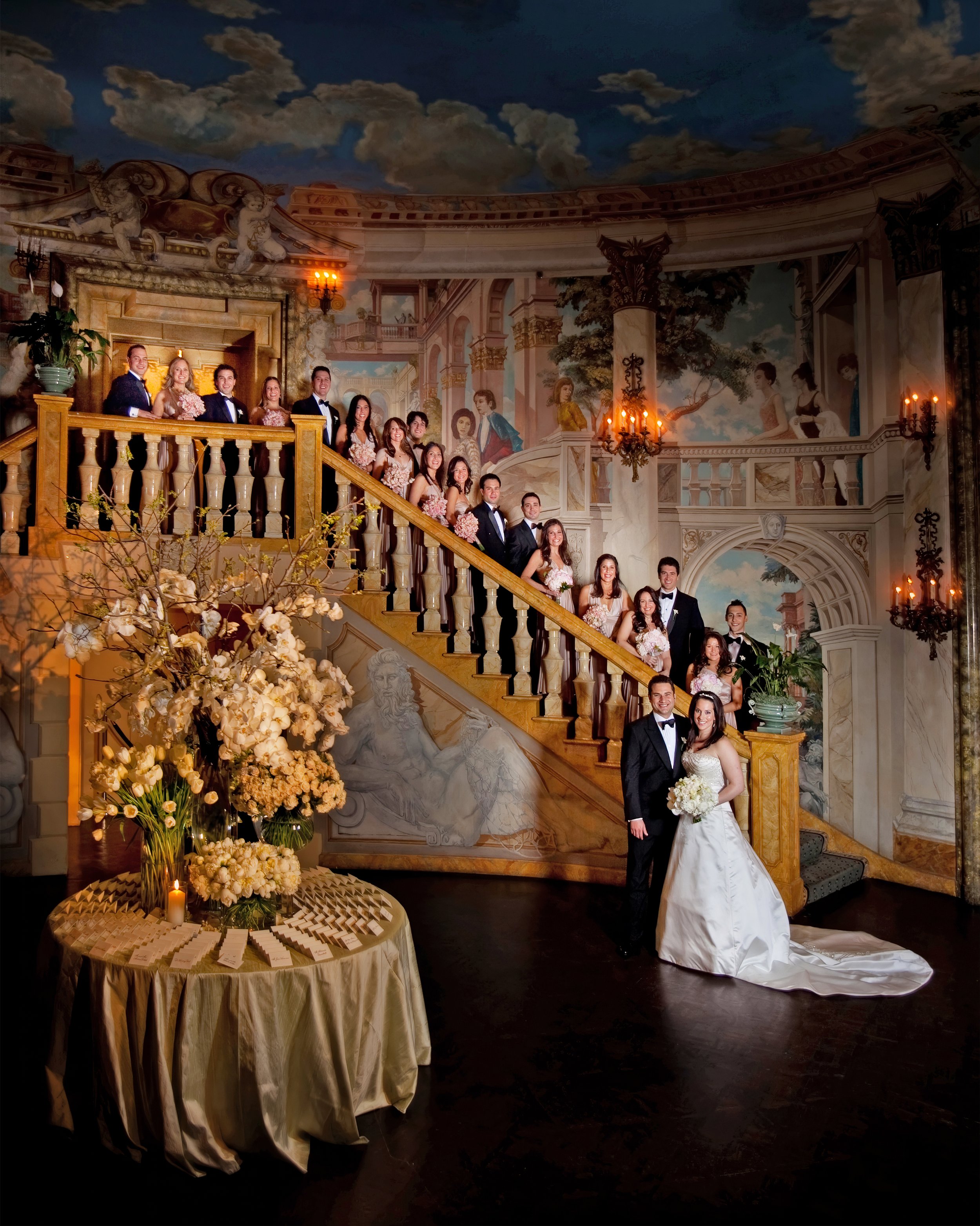 Wedding party gathered on the grand staircase in the Rotunda Room at The Pierre Hotel New York during a luxury NYC wedding.