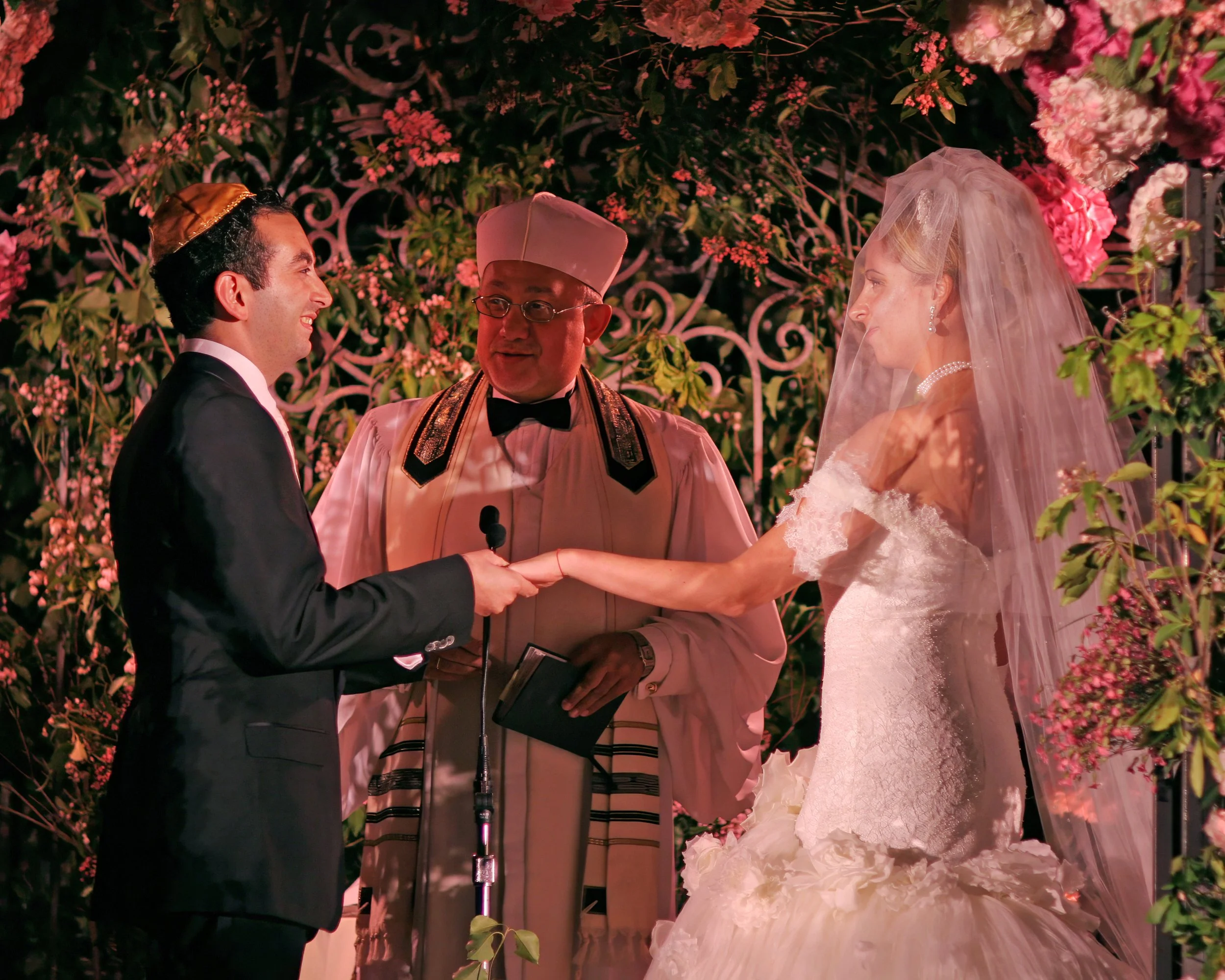 Bride and groom exchanging vows under a floral chuppah at 48 Wall Street with elegant décor.