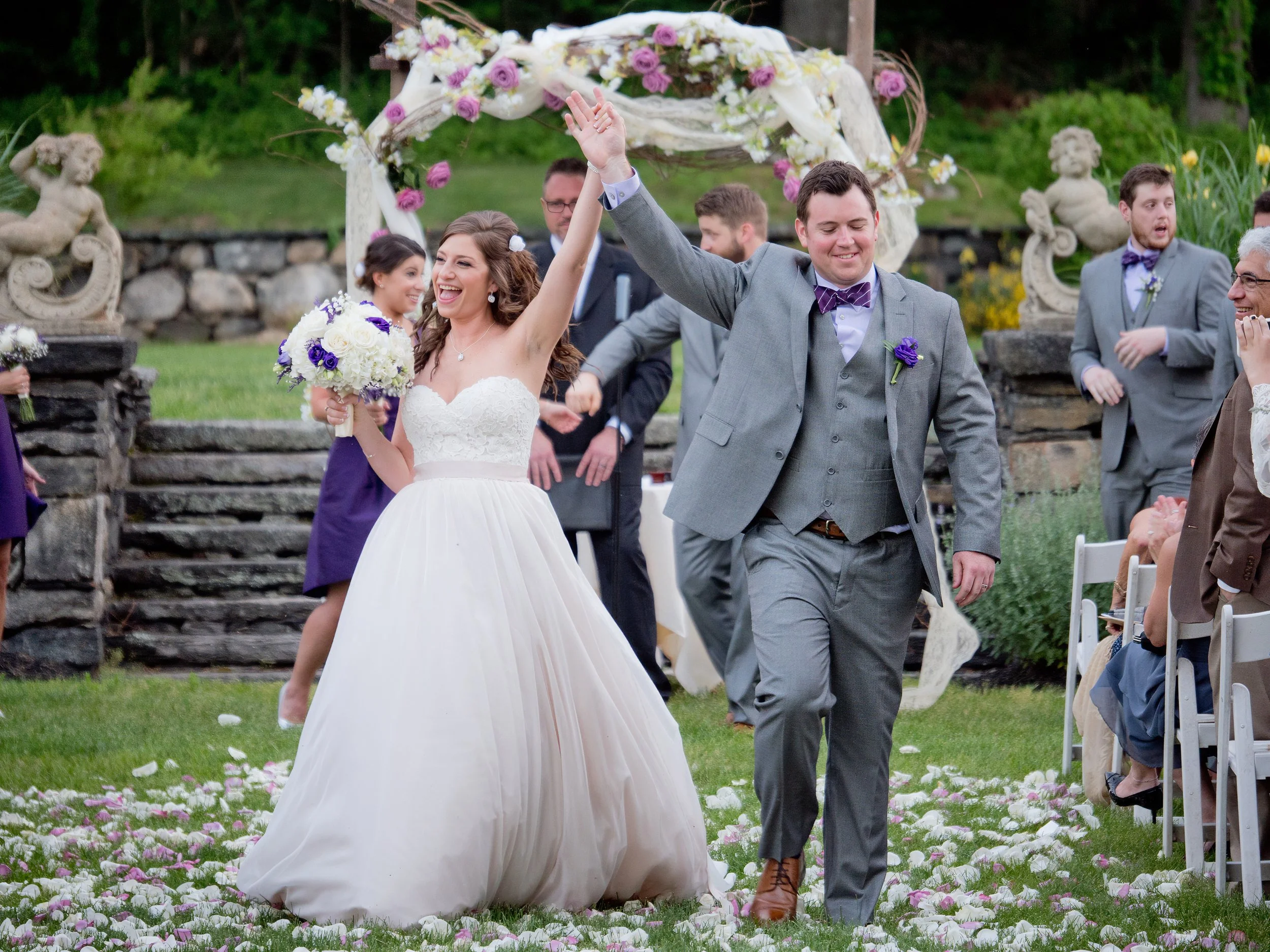 Bride and groom exiting ceremony in sunken gardens at Saint Clements Castle in Portland Connecticut during wedding celebration