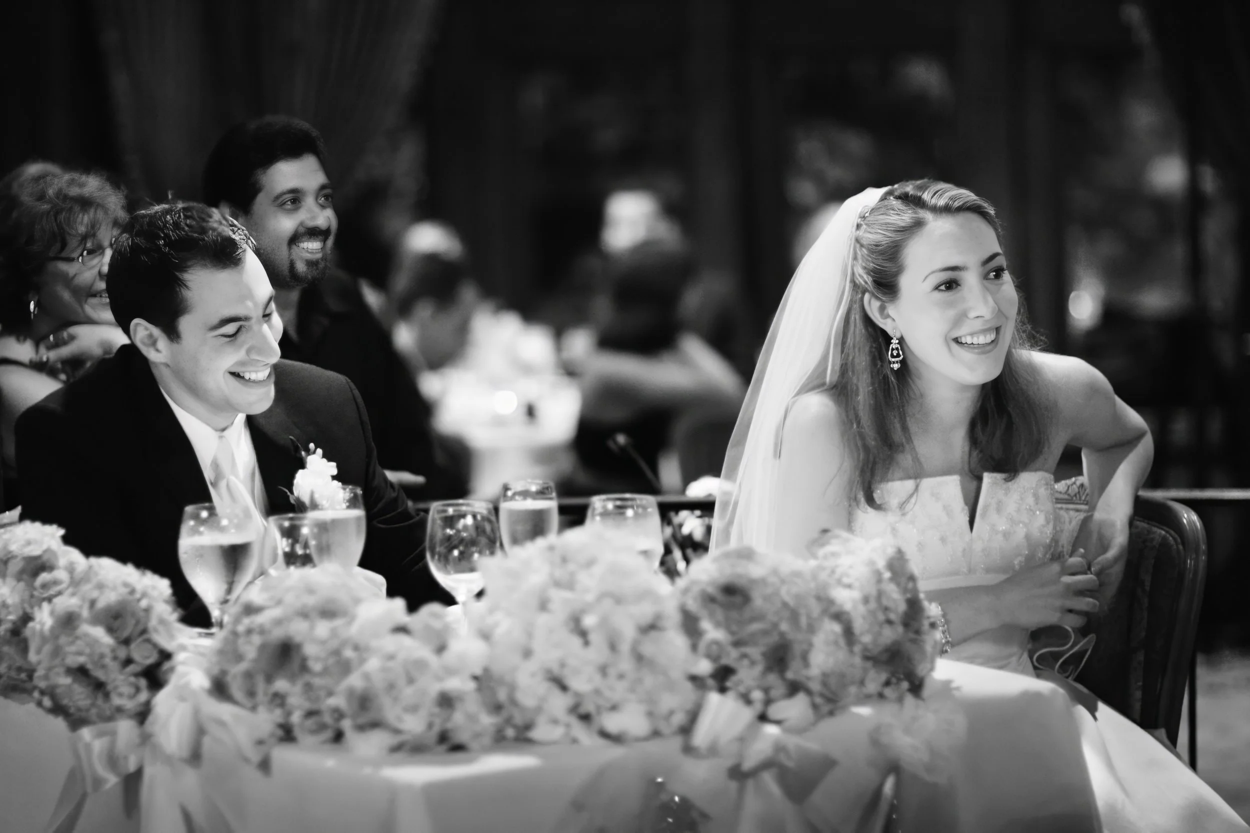 Bride and groom laugh while listening to a heartfelt wedding toast at Le Chateau