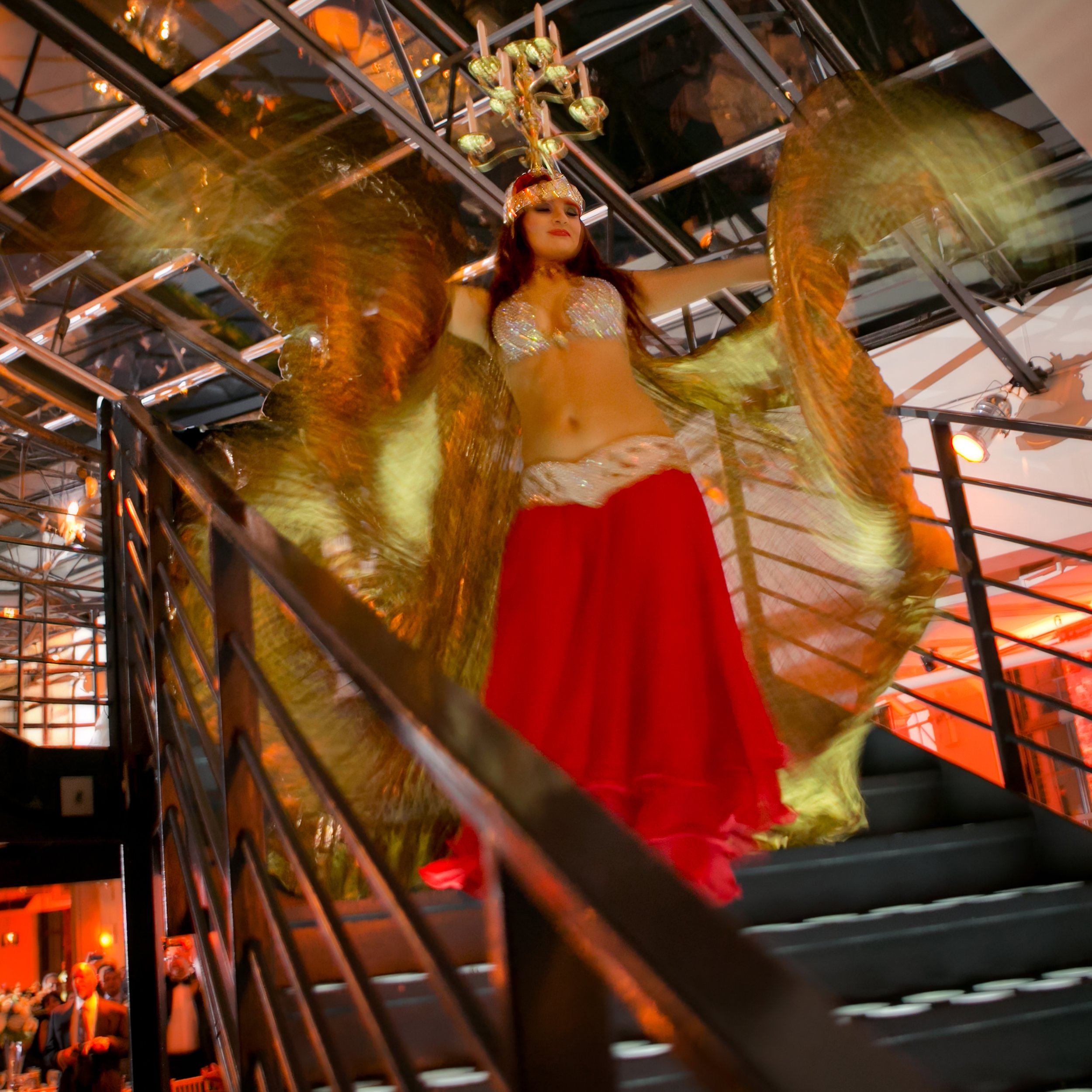 Belly dancer descending the grand staircase at Tribeca Rooftop as part of the wedding reception entertainment.