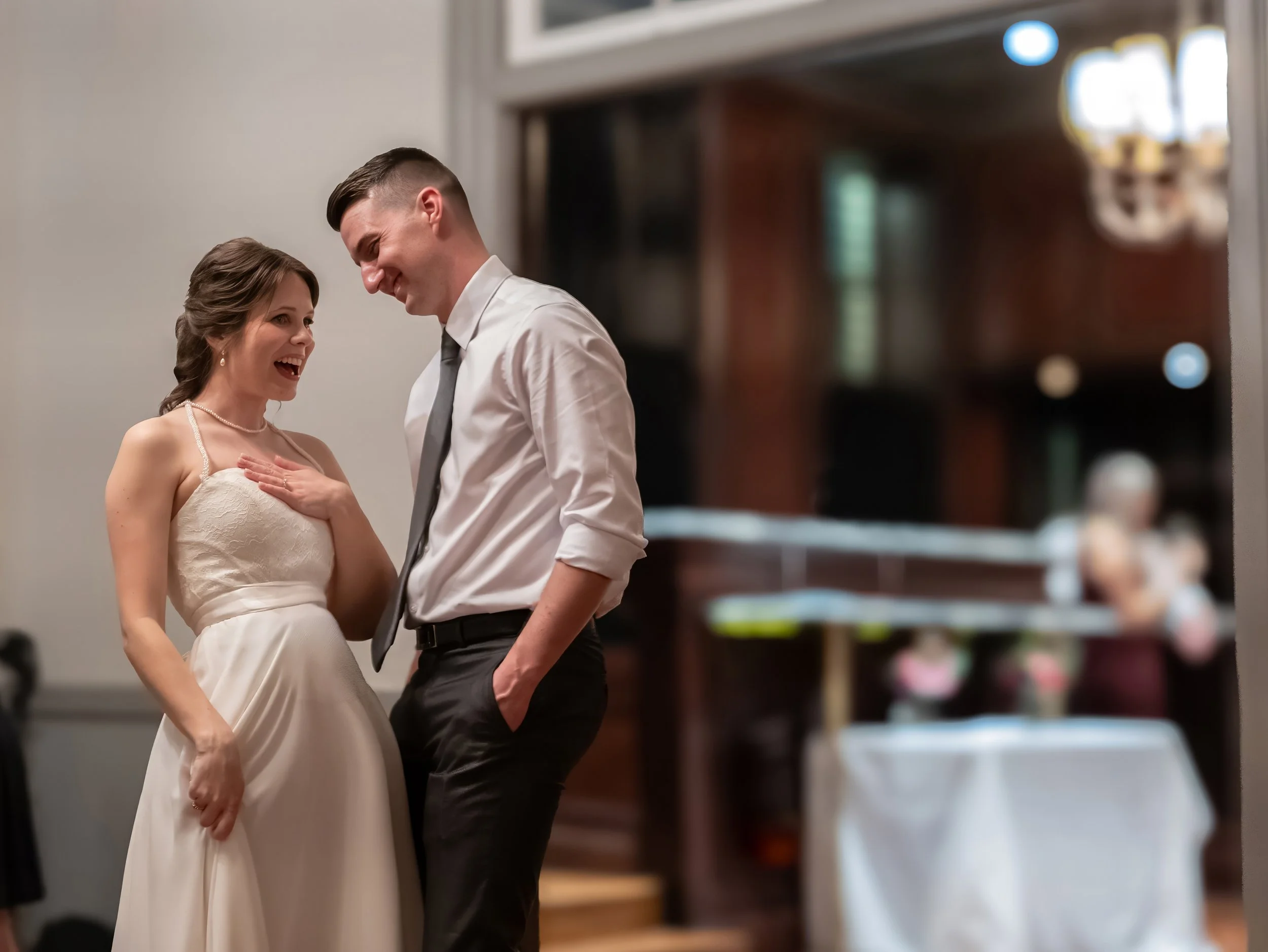 Tim and Daniella laugh together during a candid moment at their intimate Savannah wedding reception.