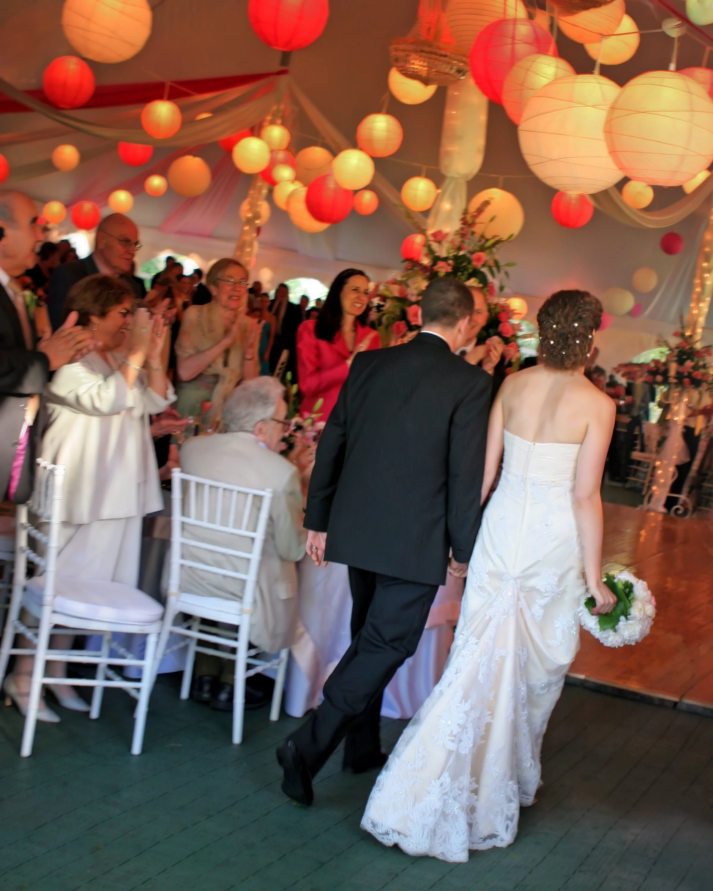 Bride and groom entering wedding reception with guests cheering at Spa at Norwich Inn