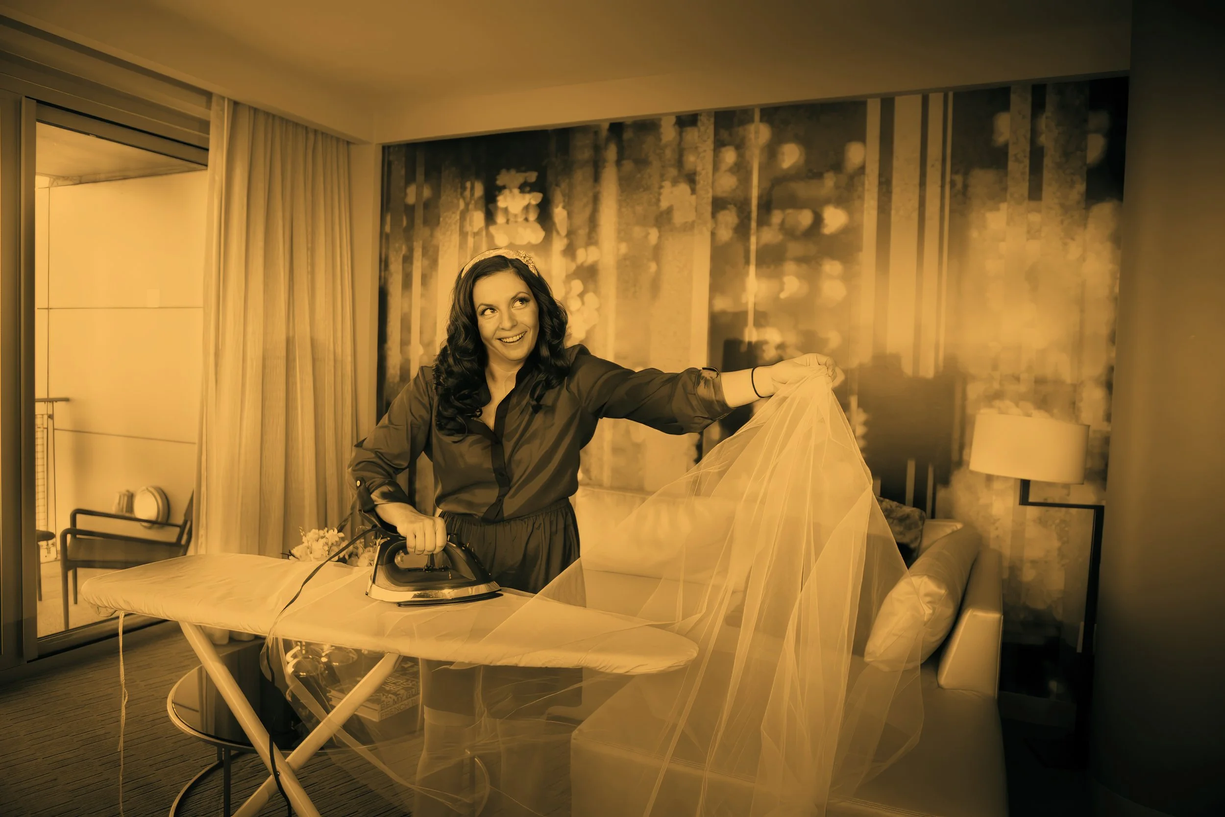 Bride playfully ironing her veil in the bridal suite at W Hoboken before getting dressed.