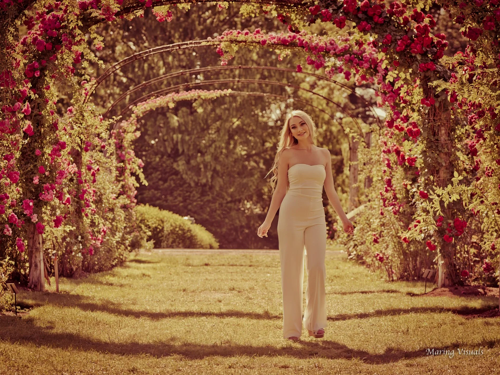 Senior portrait of Lyman Hall High School student beneath the rose garden arches at Elizabeth Park in Hartford Connecticut by Maring Visuals.
