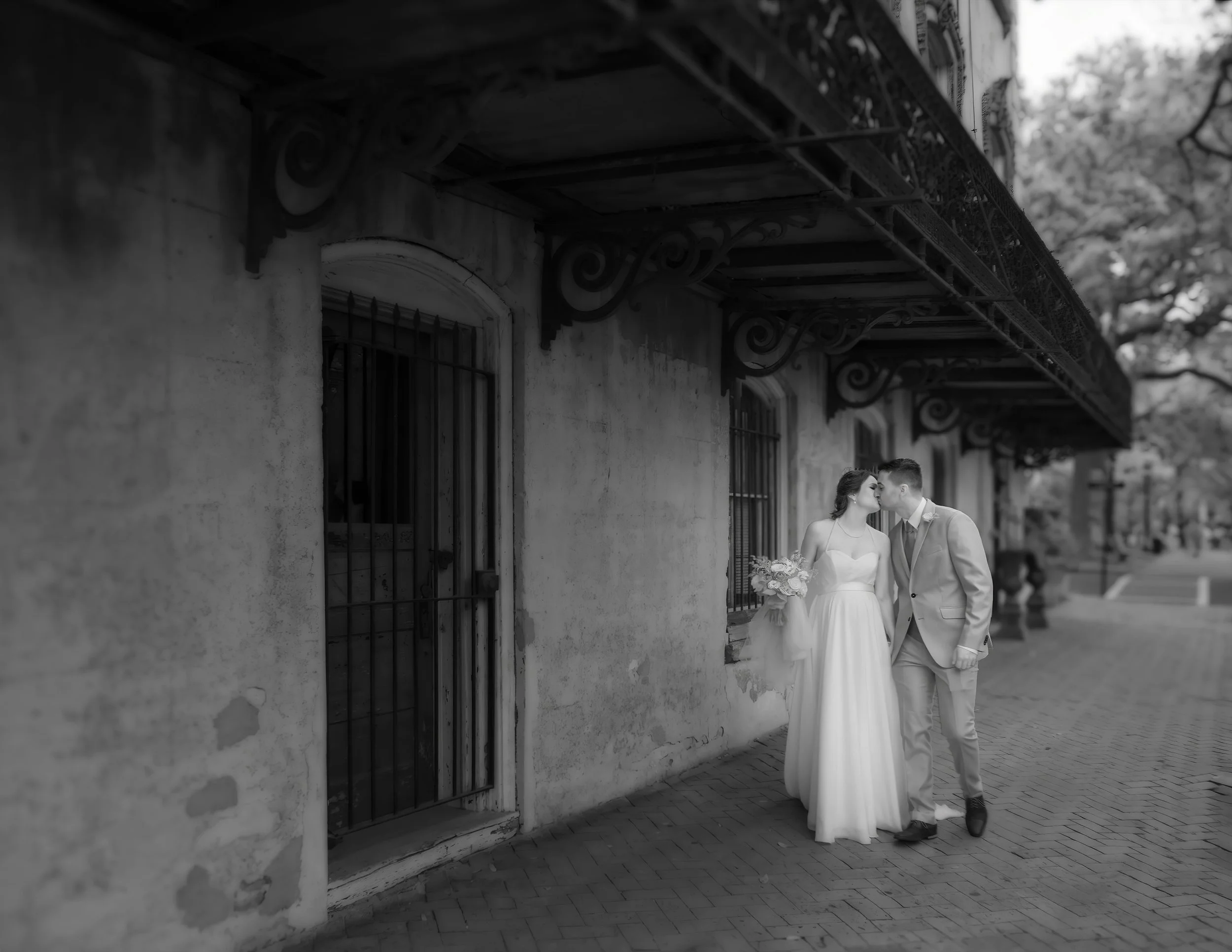 Tim and Daniella walk hand in hand through Savannah in a fine art infrared black and white wedding photograph.