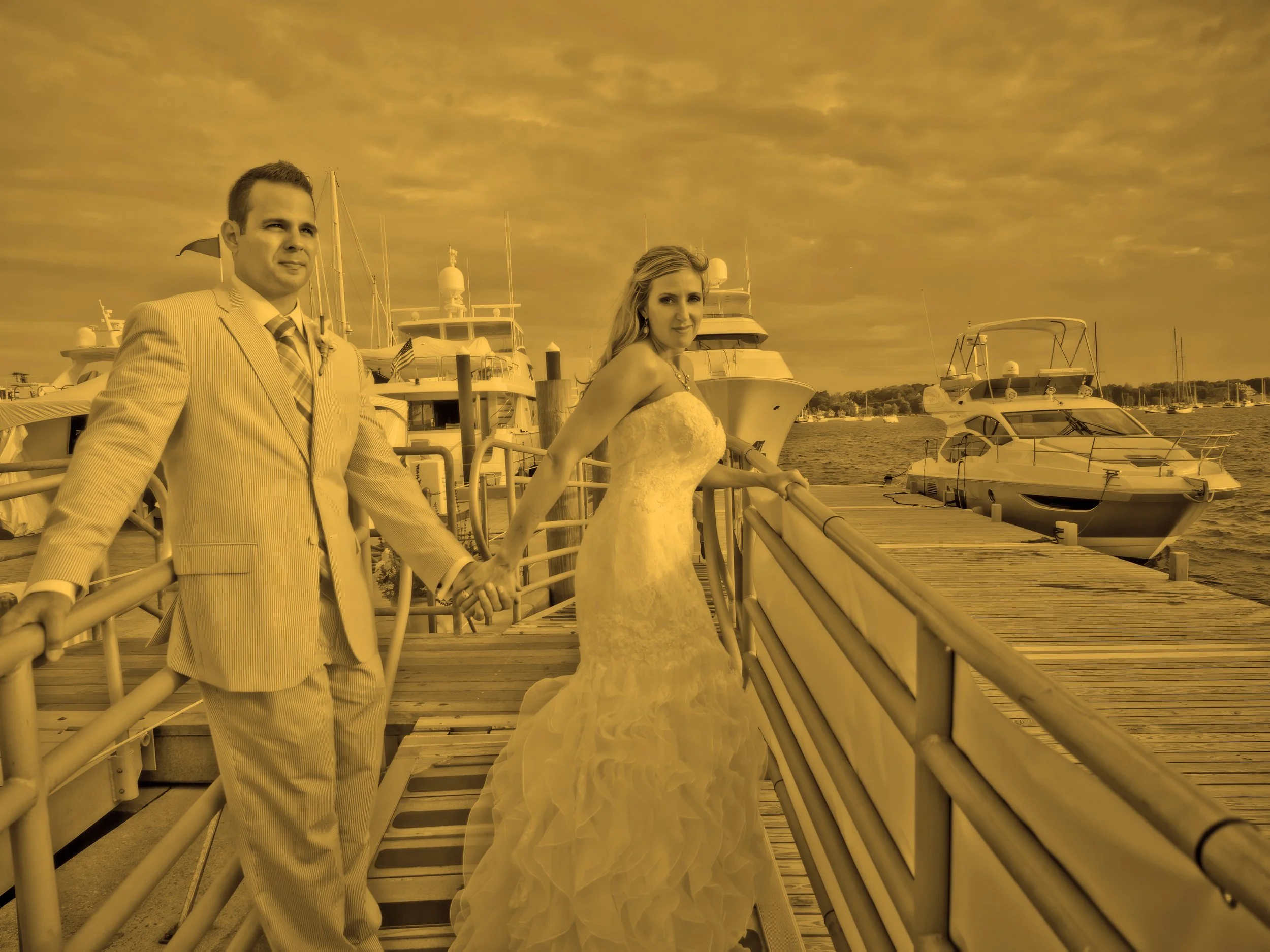 Bride and groom pose together on the dock at Newport Yachting Center.