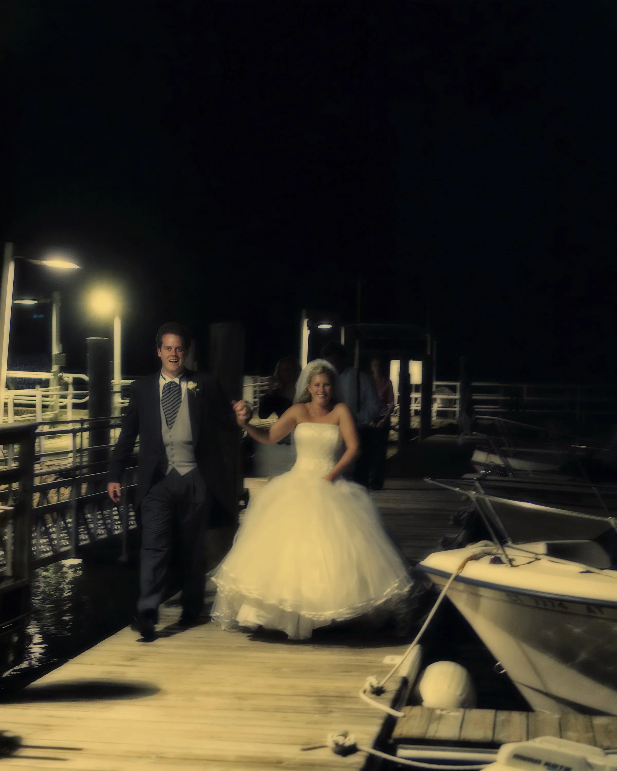 Bride and groom make their wedding exit along the docks at Belle Haven Yacht Club.