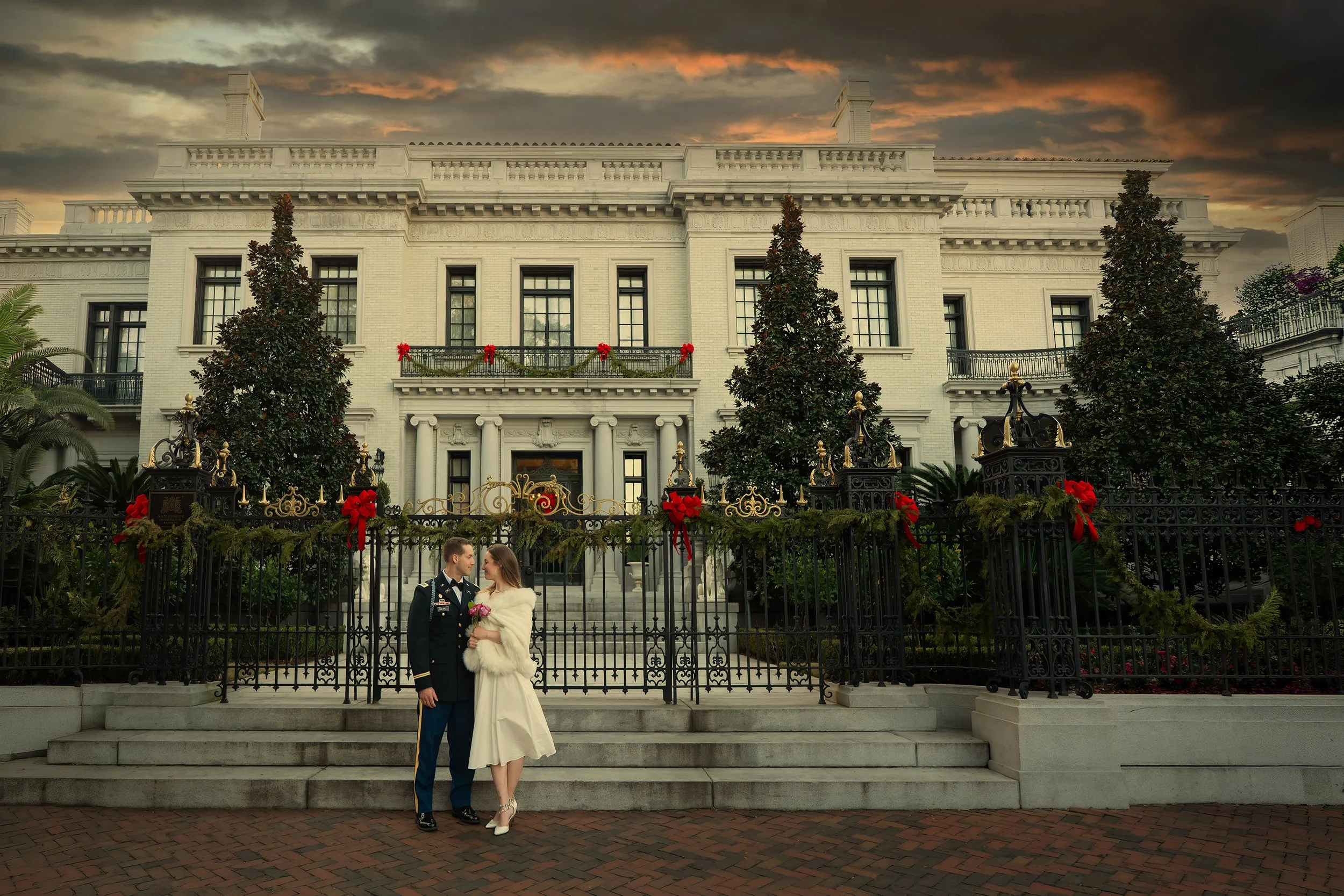 Bride and groom pose in front of Armstrong Kessler Mansion adjacent to Forsyth Park in Savannah, Georgia.