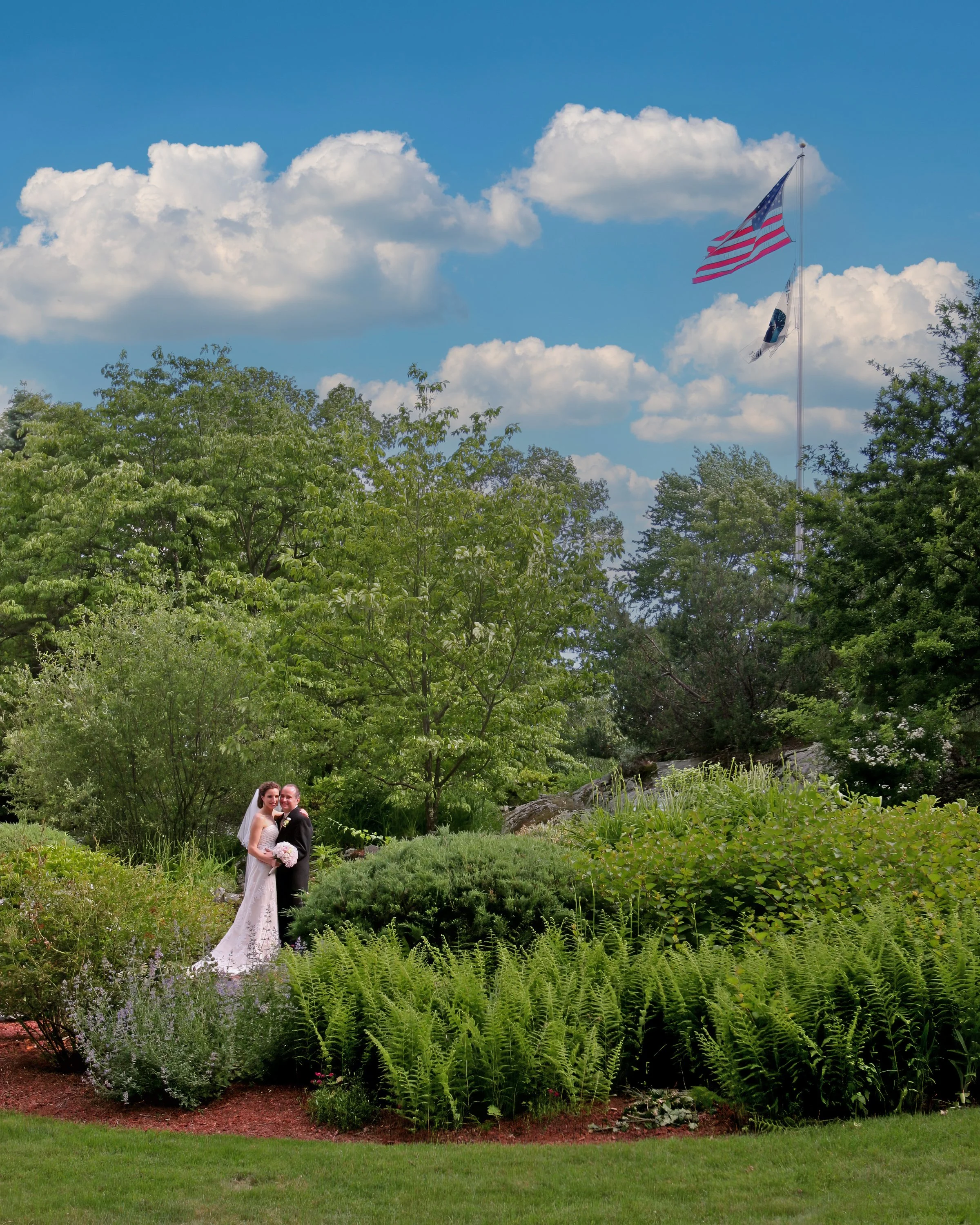 Bride and groom pose for a classic portrait in the lush gardens of the Spa at Norwich Inn.