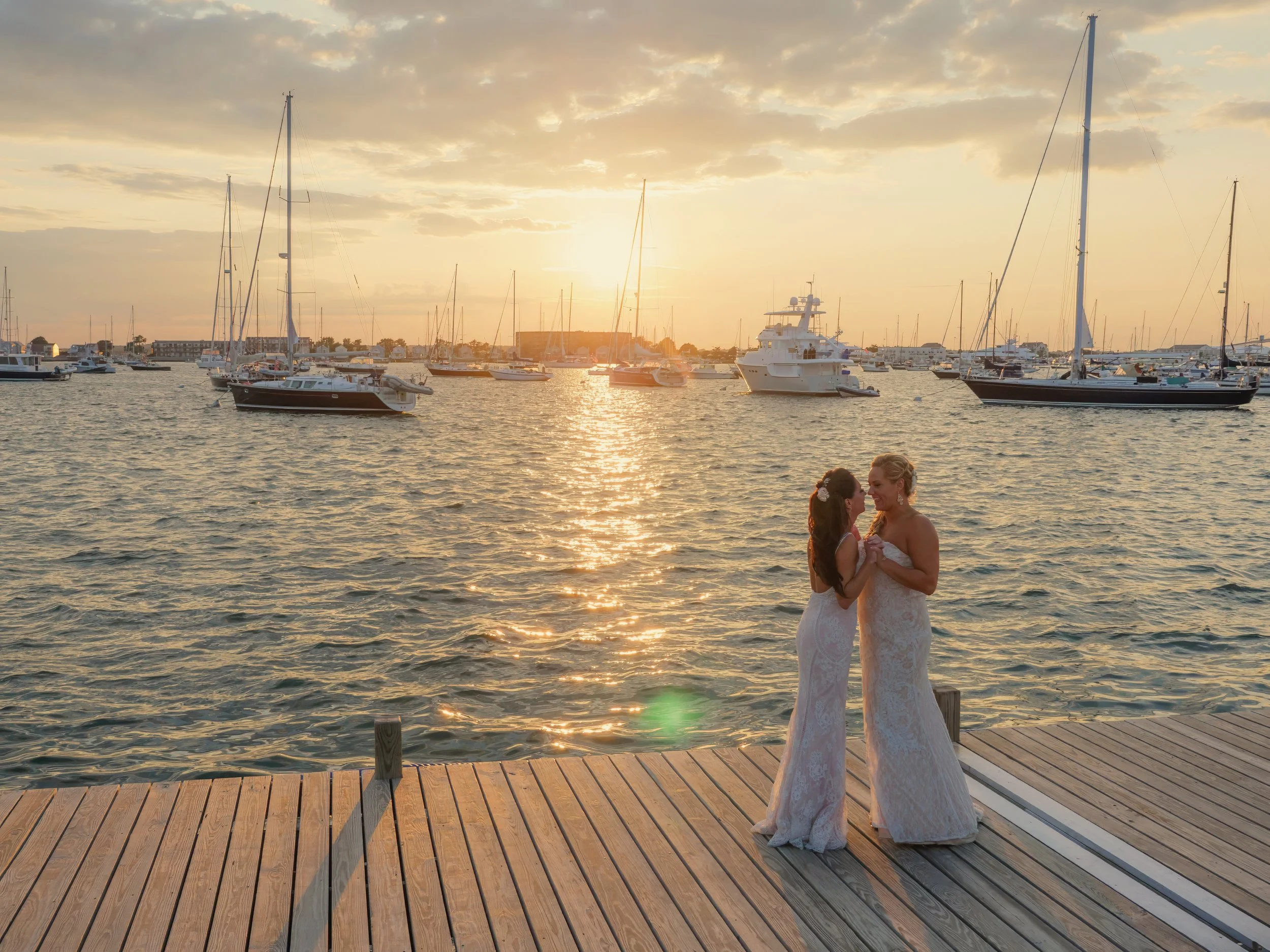 Wedding couple dances on the docks at sunset overlooking the harbor at the Newport Yachting Center.