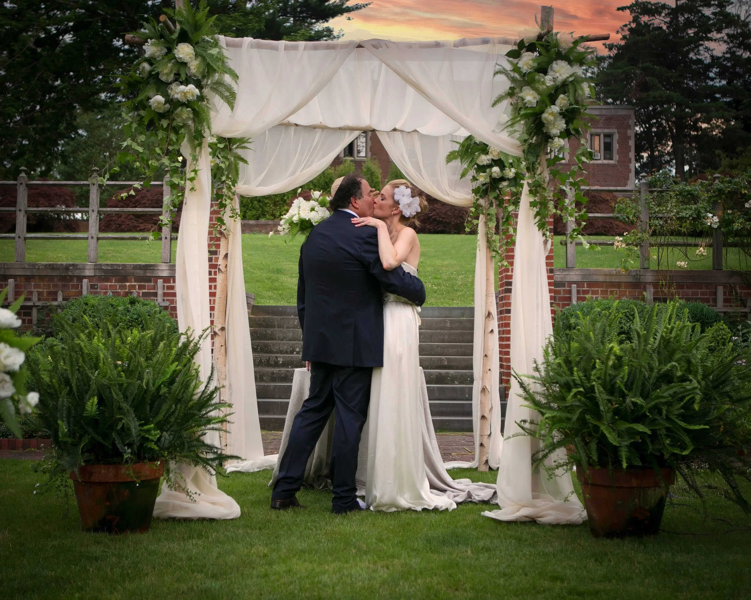 Bride and groom sharing a kiss during their outdoor ceremony at Waveny House in New Canaan, Connecticut.