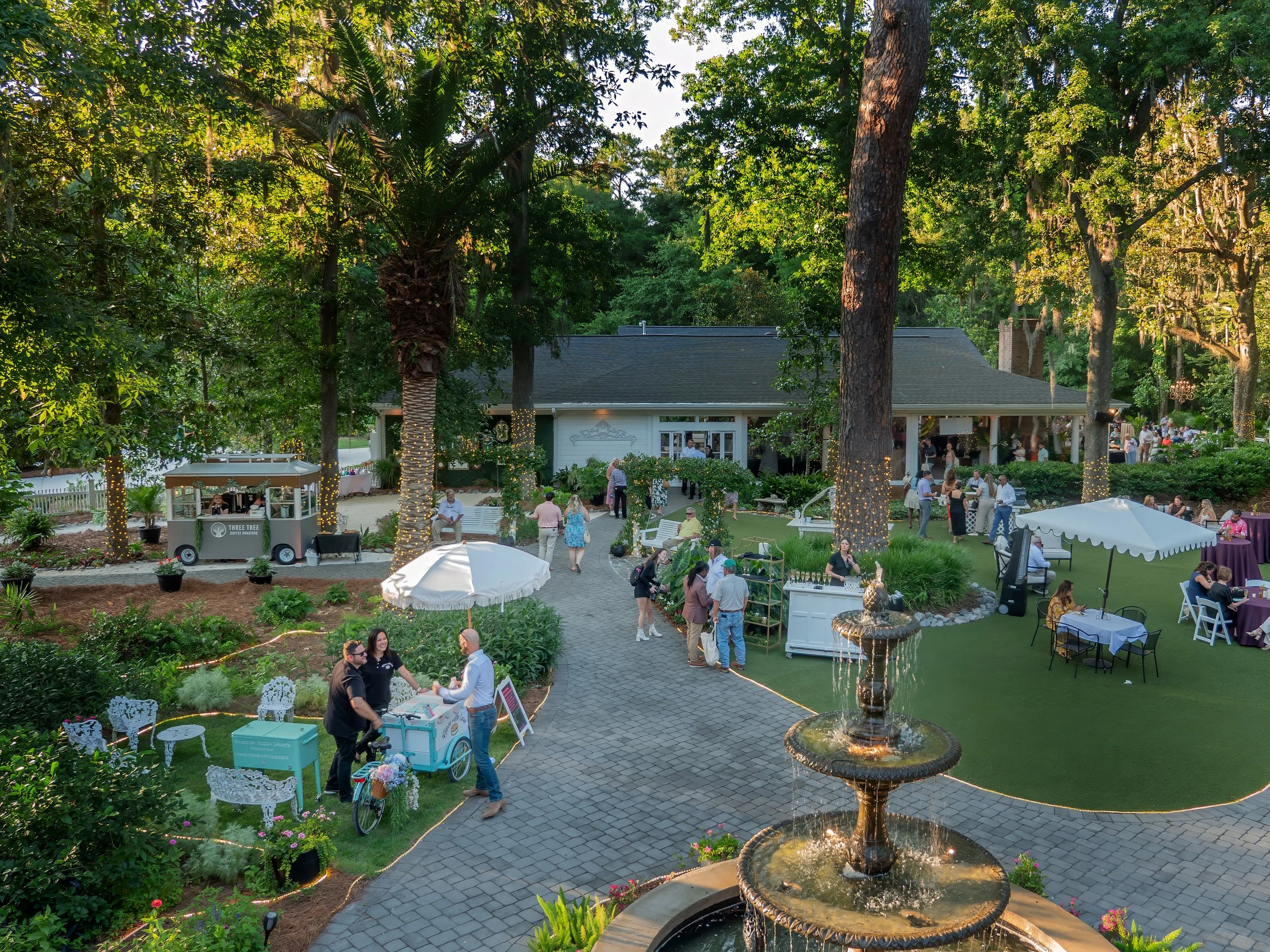 Guests gather and explore entertainment experiences during a corporate event in the garden at The Mackey House in Savannah Georgia.