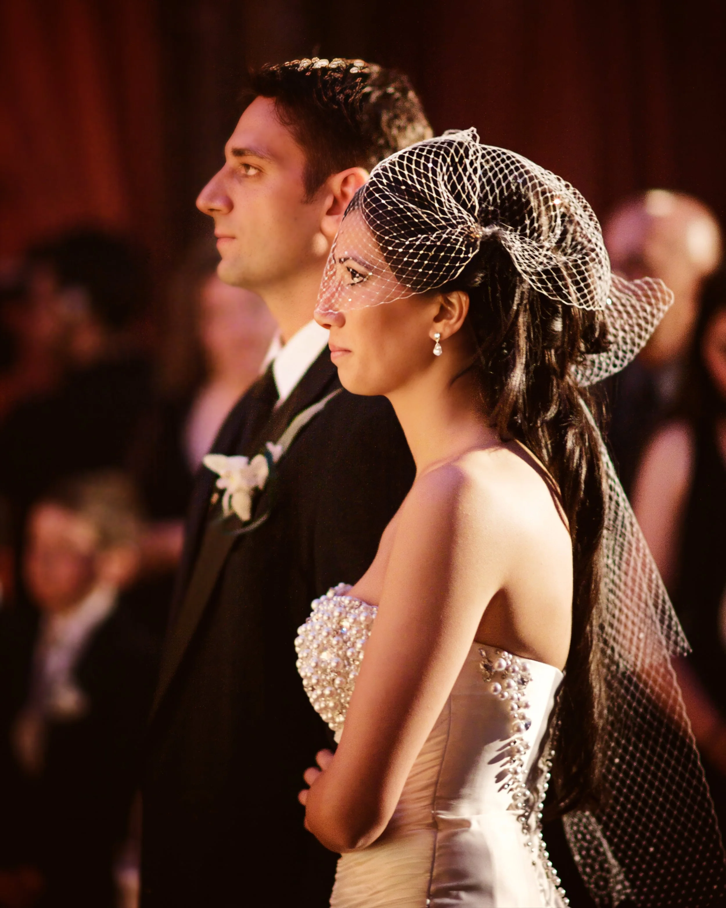 Bride and groom stand arm in arm during their wedding ceremony at Angel Orensanz.