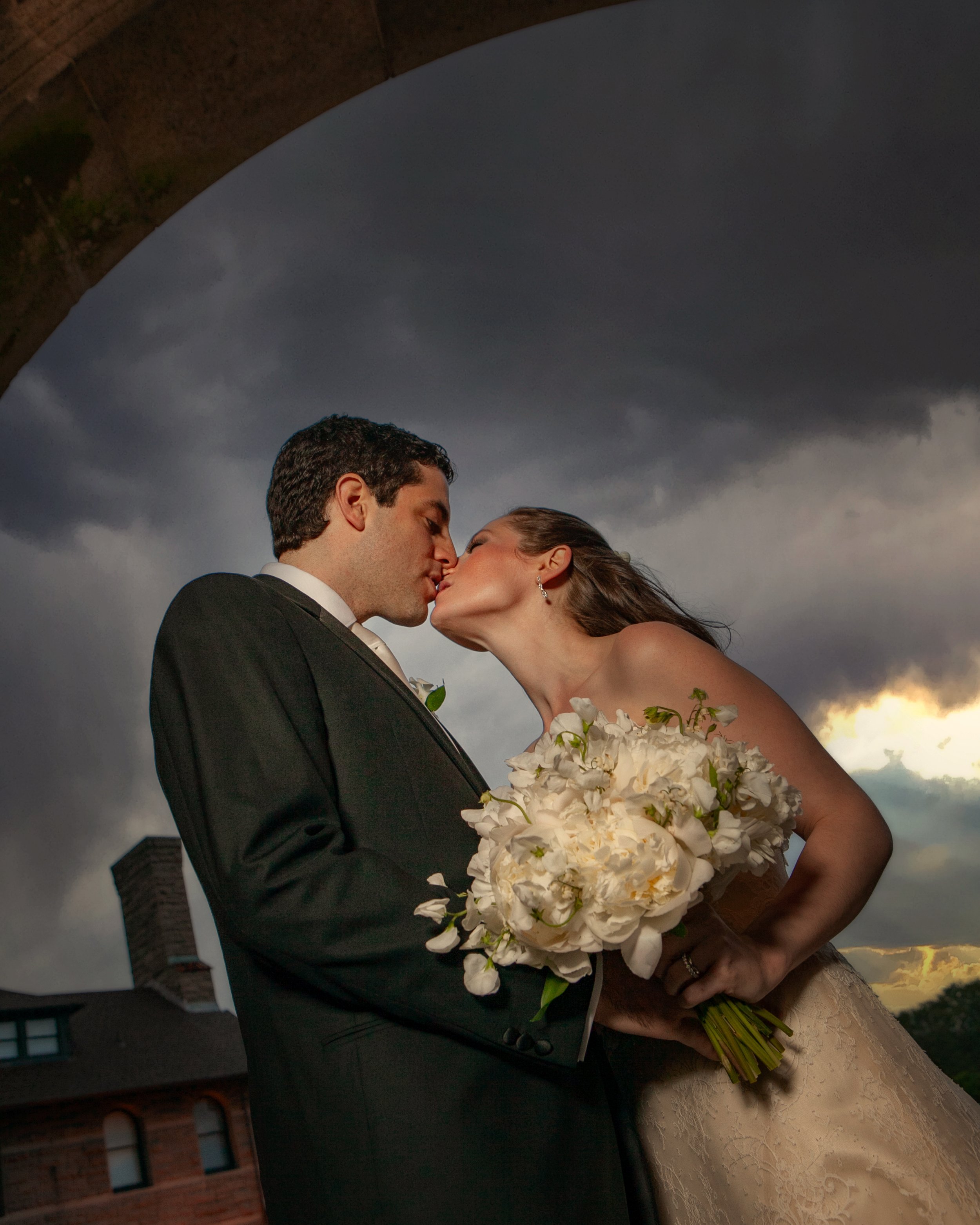 Romantic kiss under the archways at Ocean Cliff with stormy sky.