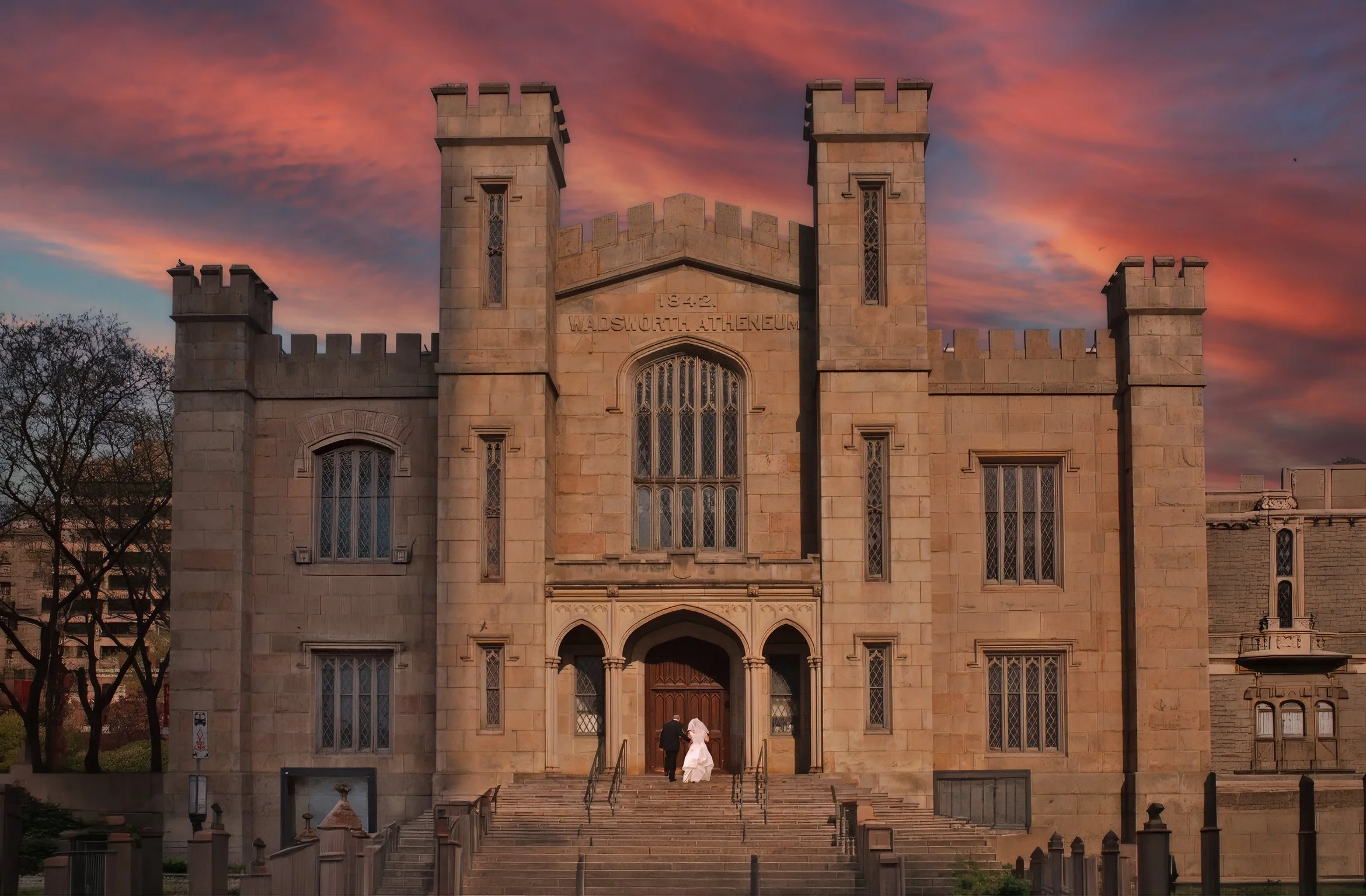 Bride and groom ascend the front steps of the Wadsworth Atheneum together for a sweeping grand portrait.