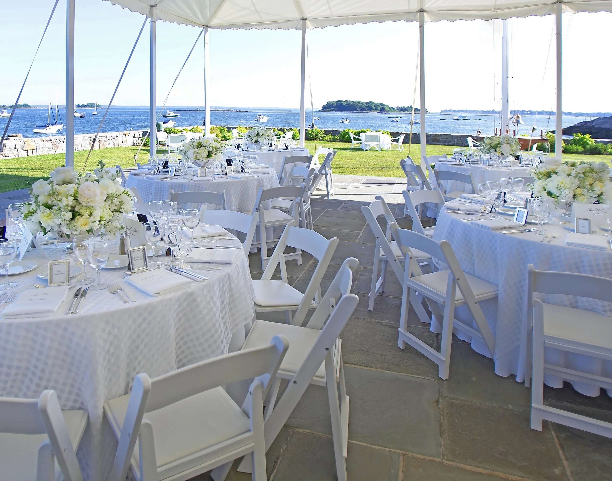 Tented wedding reception decor and floral overlooking the harbor at Belle Haven Yacht Club.