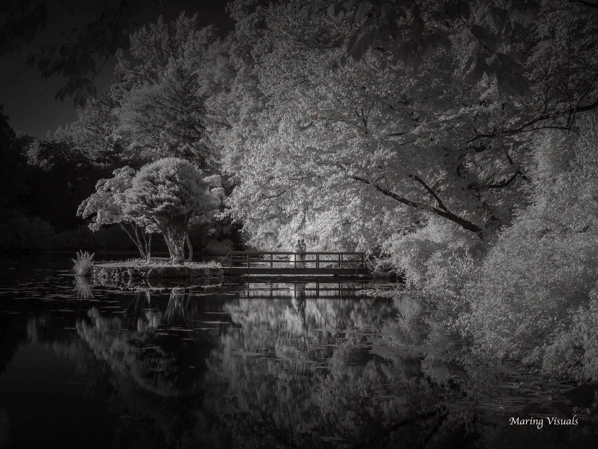 A tranquil pond at Whispering Oaks with a wedding couple
