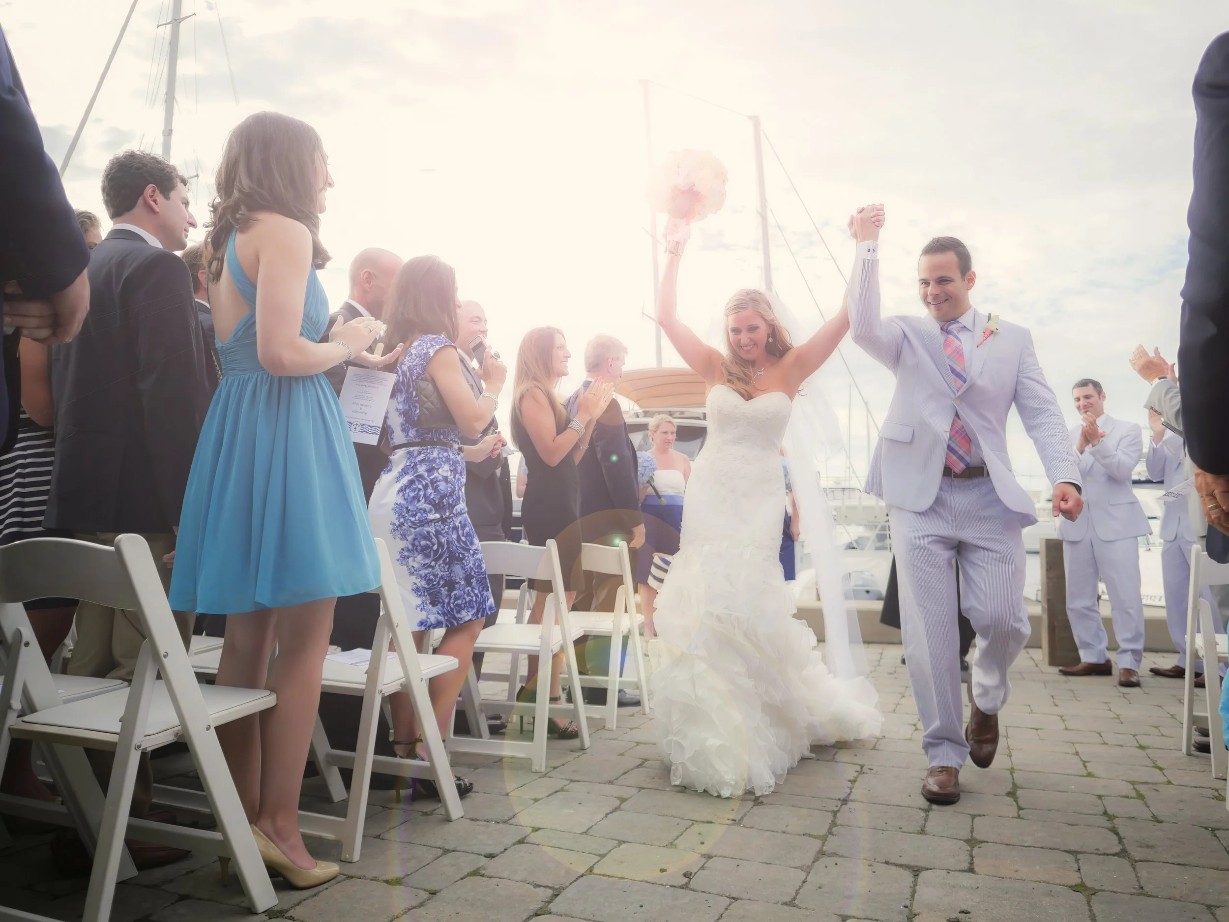 Joyful wedding ceremony recessional at the Newport Yachting Center with family and friends celebrating.