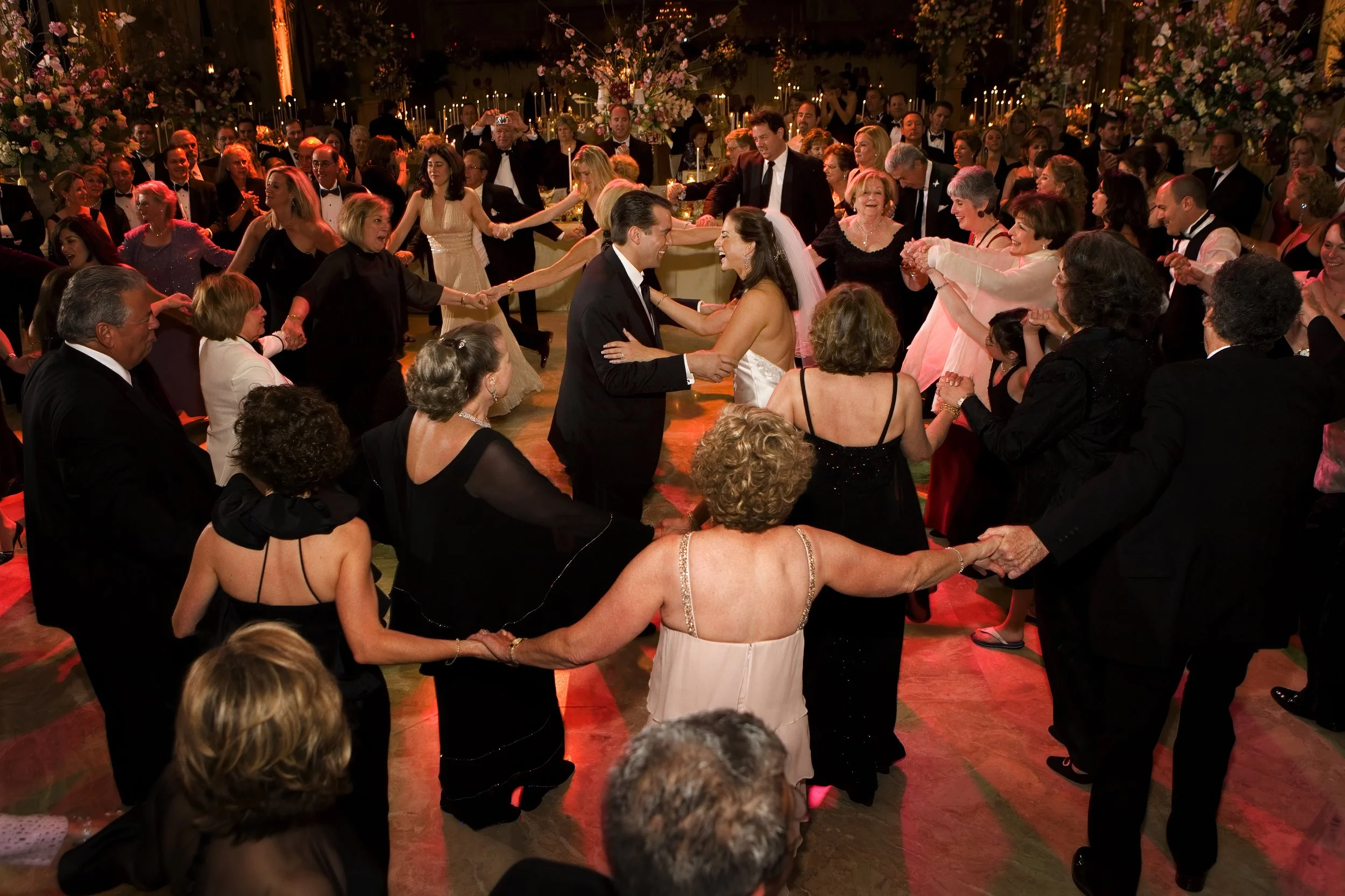 A bride and groom are encircled by family and friends during the Horah dance