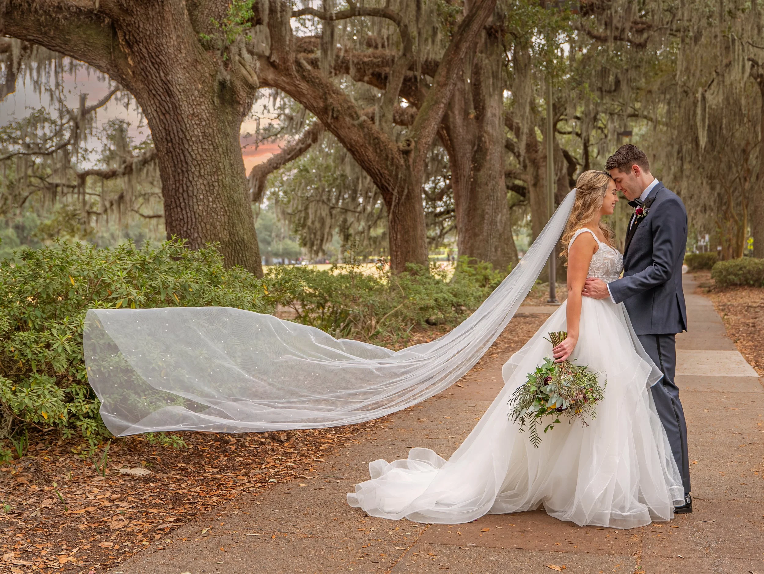 Bride and groom share a romantic moment on the sidewalk at Hall Street and Whitaker Street near Forsyth Park, Savannah.