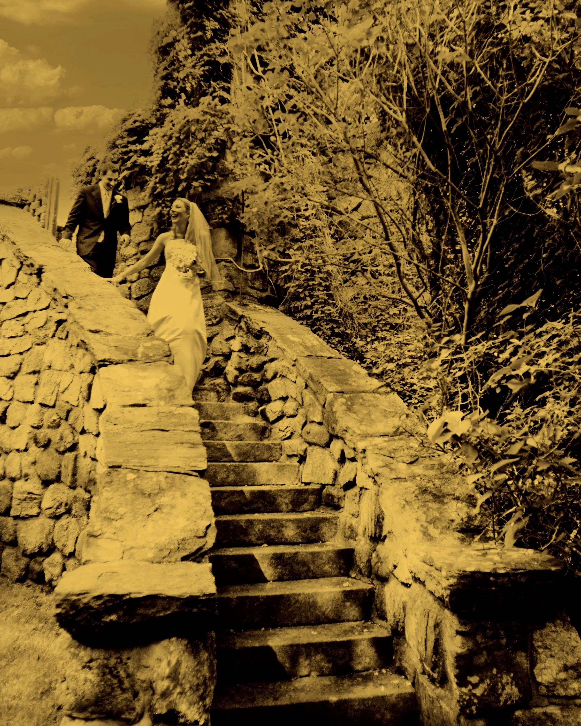 Bride and groom joyfully walk down a stone staircase on the grounds of Le Chateau in Westchester County New York