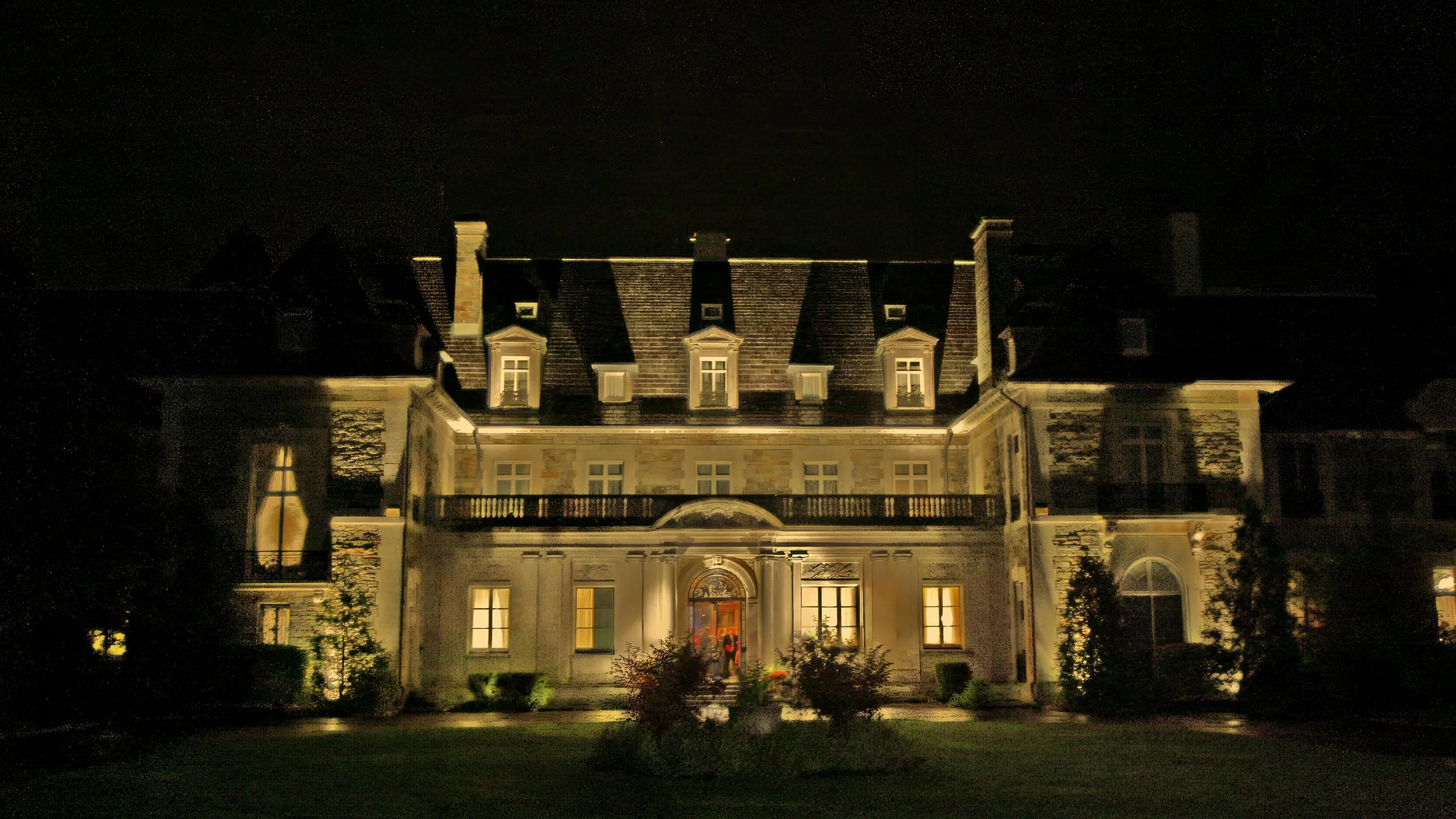 Aldrich Mansion illuminated at night with dramatic lighting across the historic exterior.