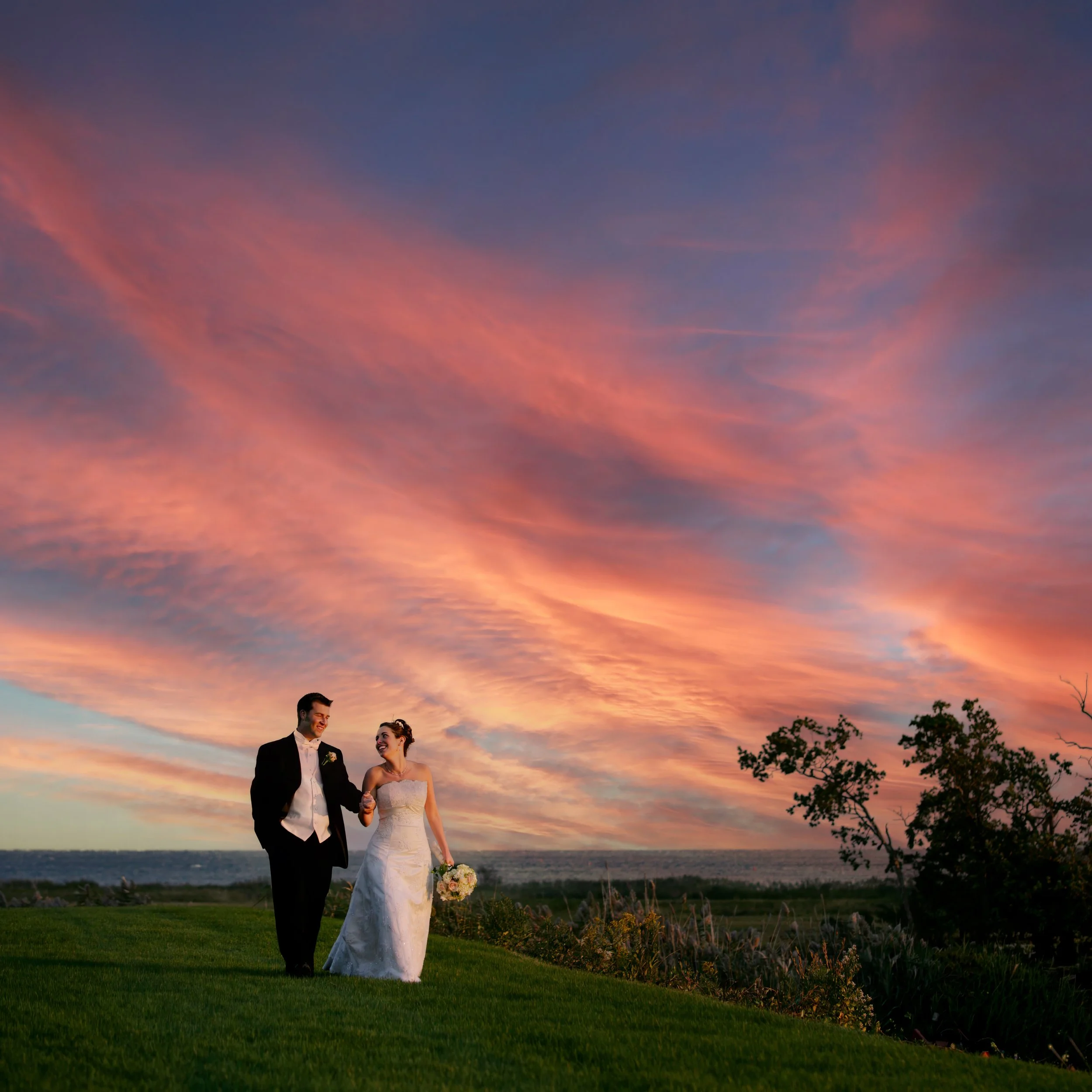Bride and groom share a romantic sunset walk on the grounds of Guilford Yacht Club.