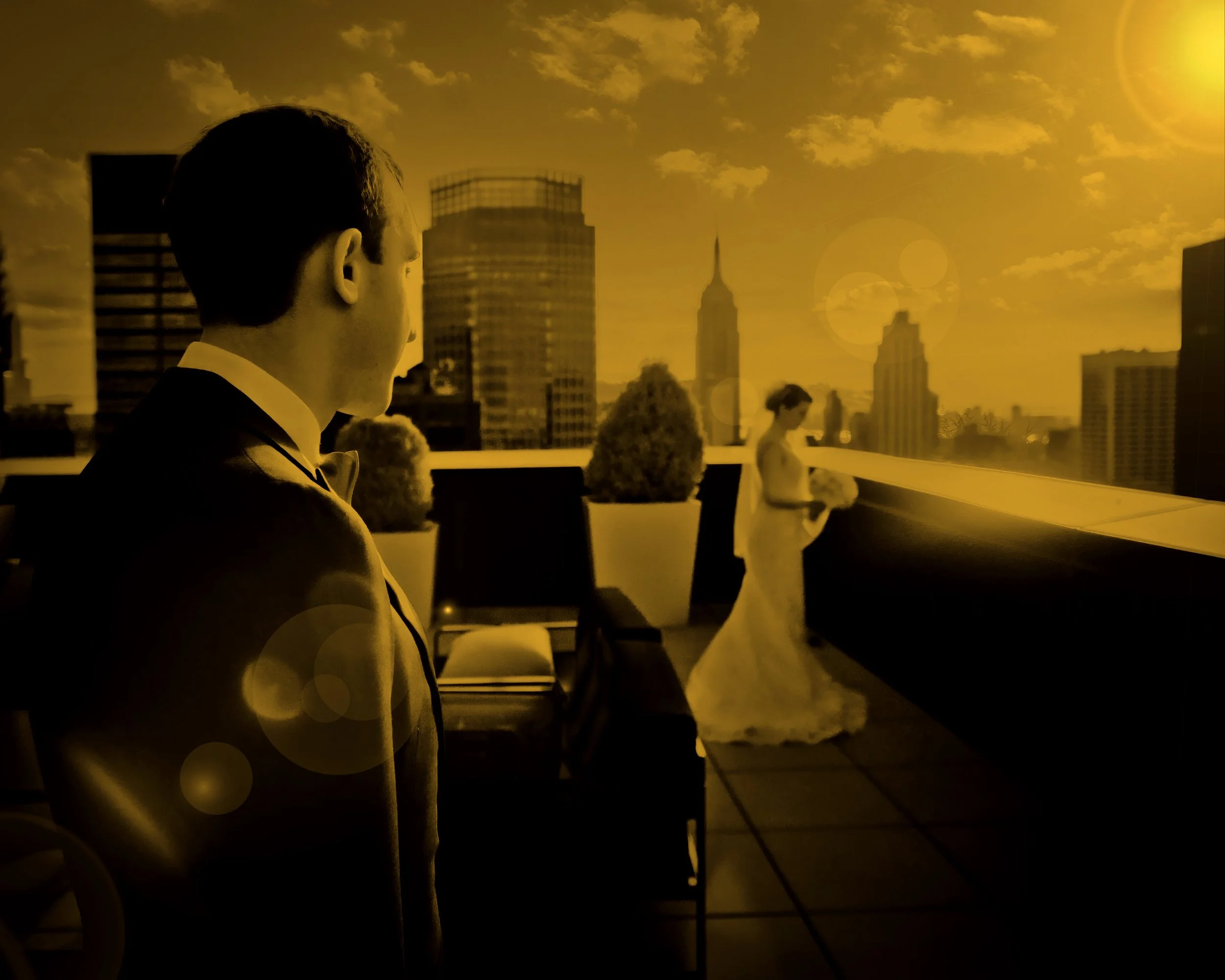 Fine art portrait of a groom looking lovingly at his bride with sun flare and the Manhattan skyline behind them.