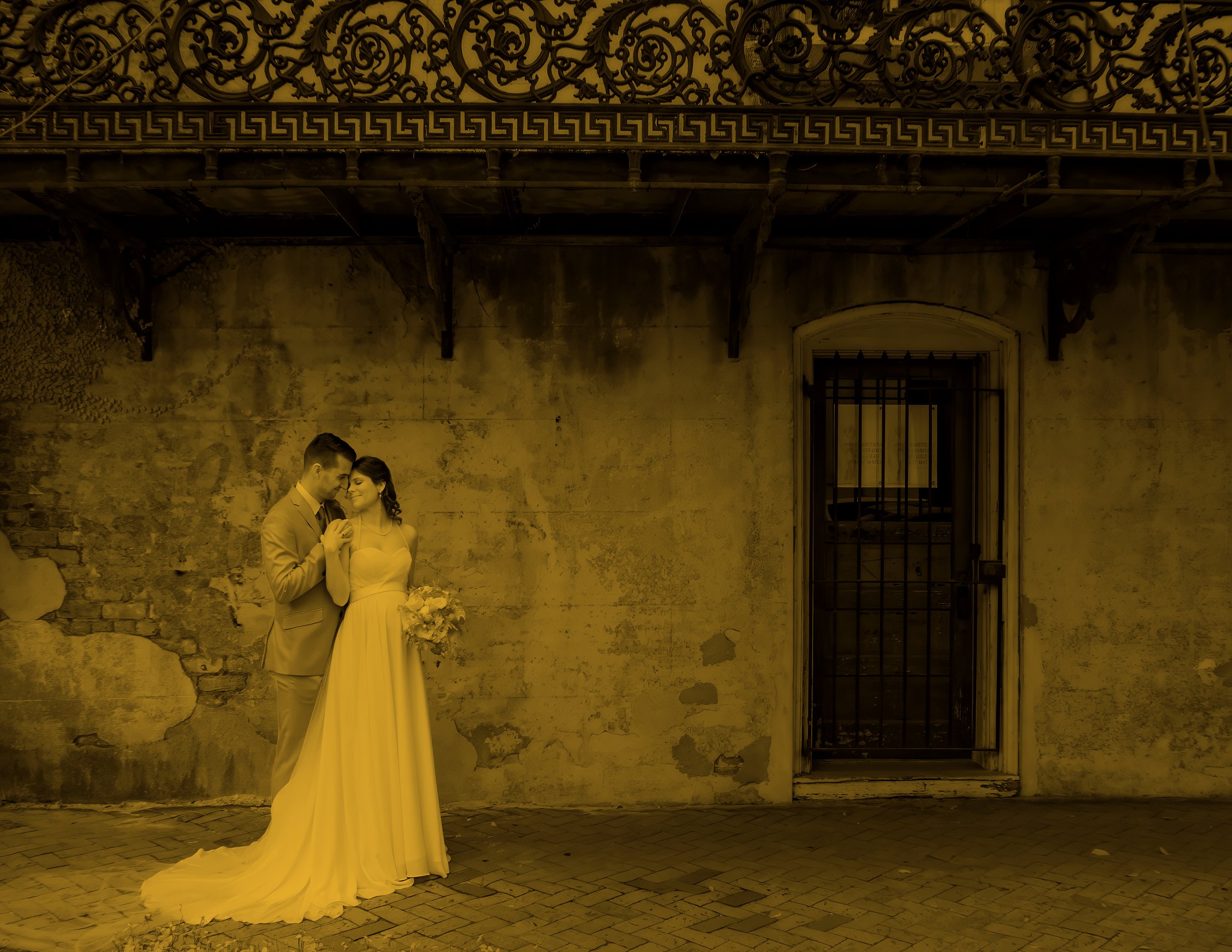 Tim embraces Daniella beside a weathered historic wall during their Savannah micro wedding portrait session.