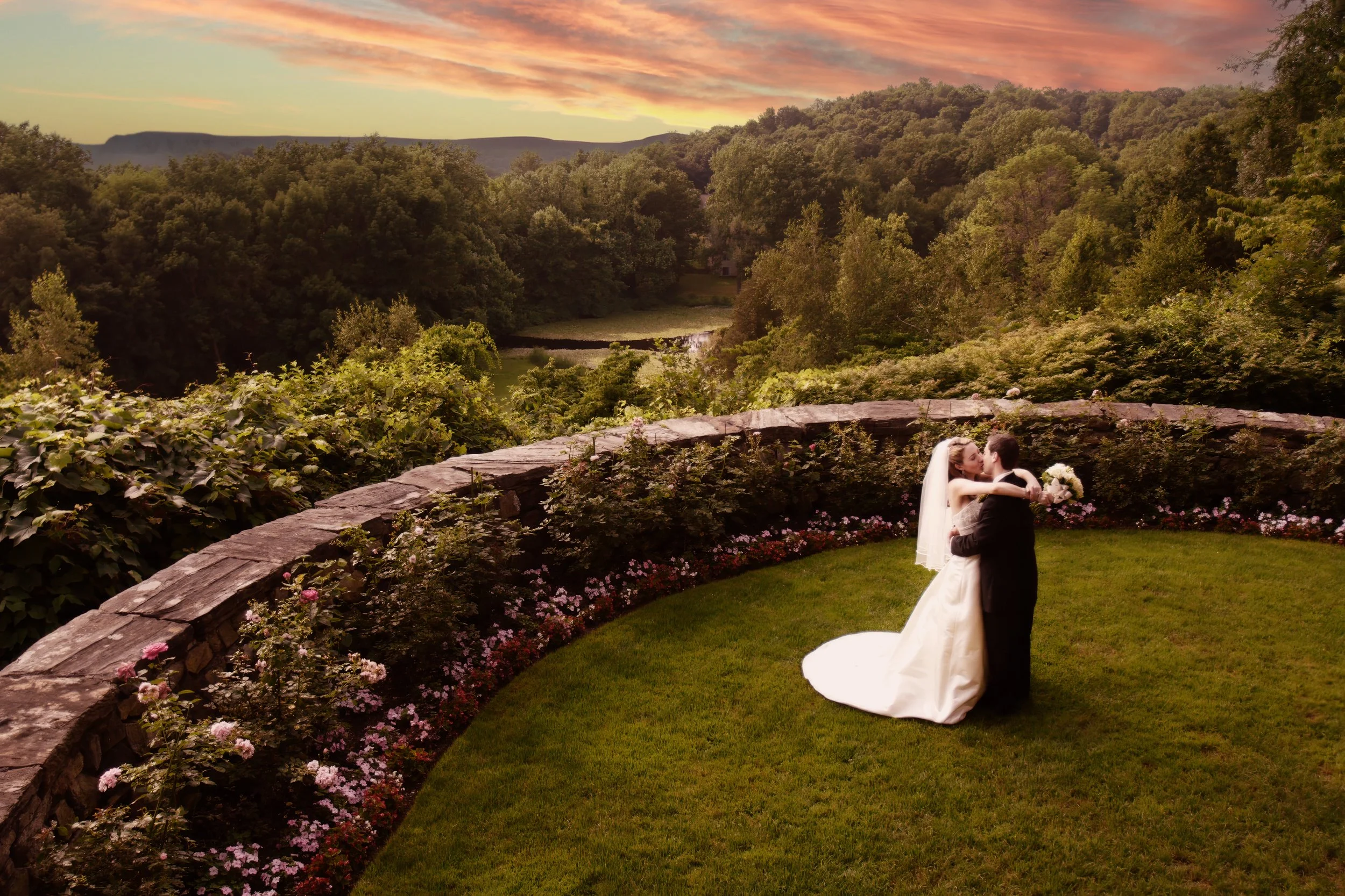Bride and groom kiss with a Hudson Valley sunset view at Le Chateau in South Salem NY