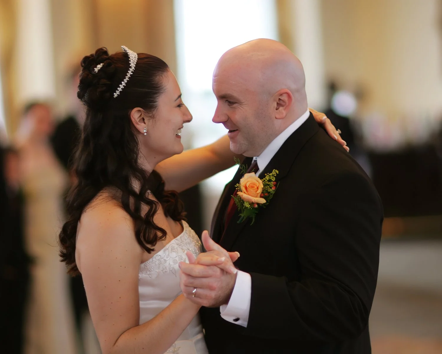 Closeup of bride and groom sharing a joyful moment during their first dance at Bond Ballroom.