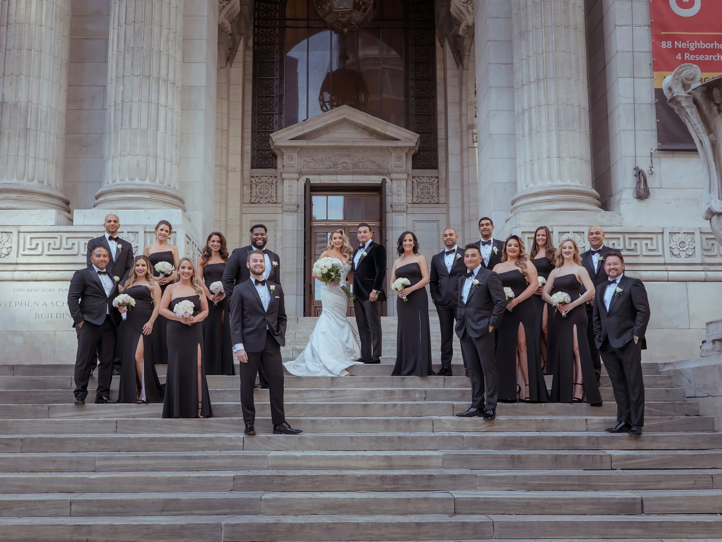 Wedding party group photo on the steps of the New York Public Library NYC wedding venue