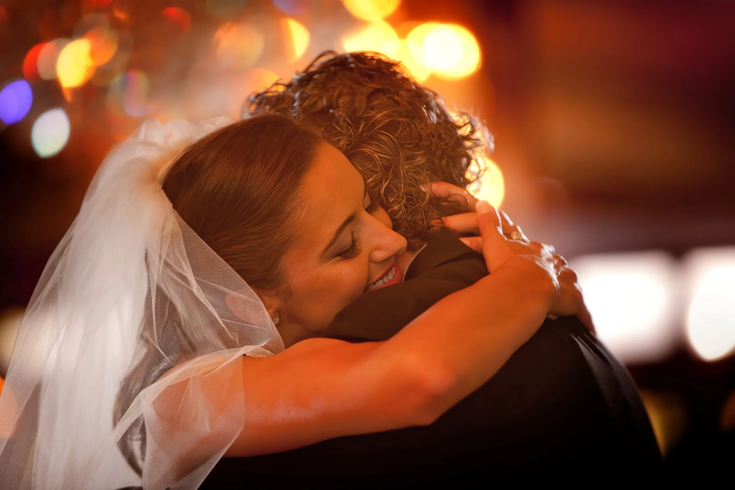 Bride hugs the groom on the dance floor of the Waterford Ballroom at Saint Clements Castle.