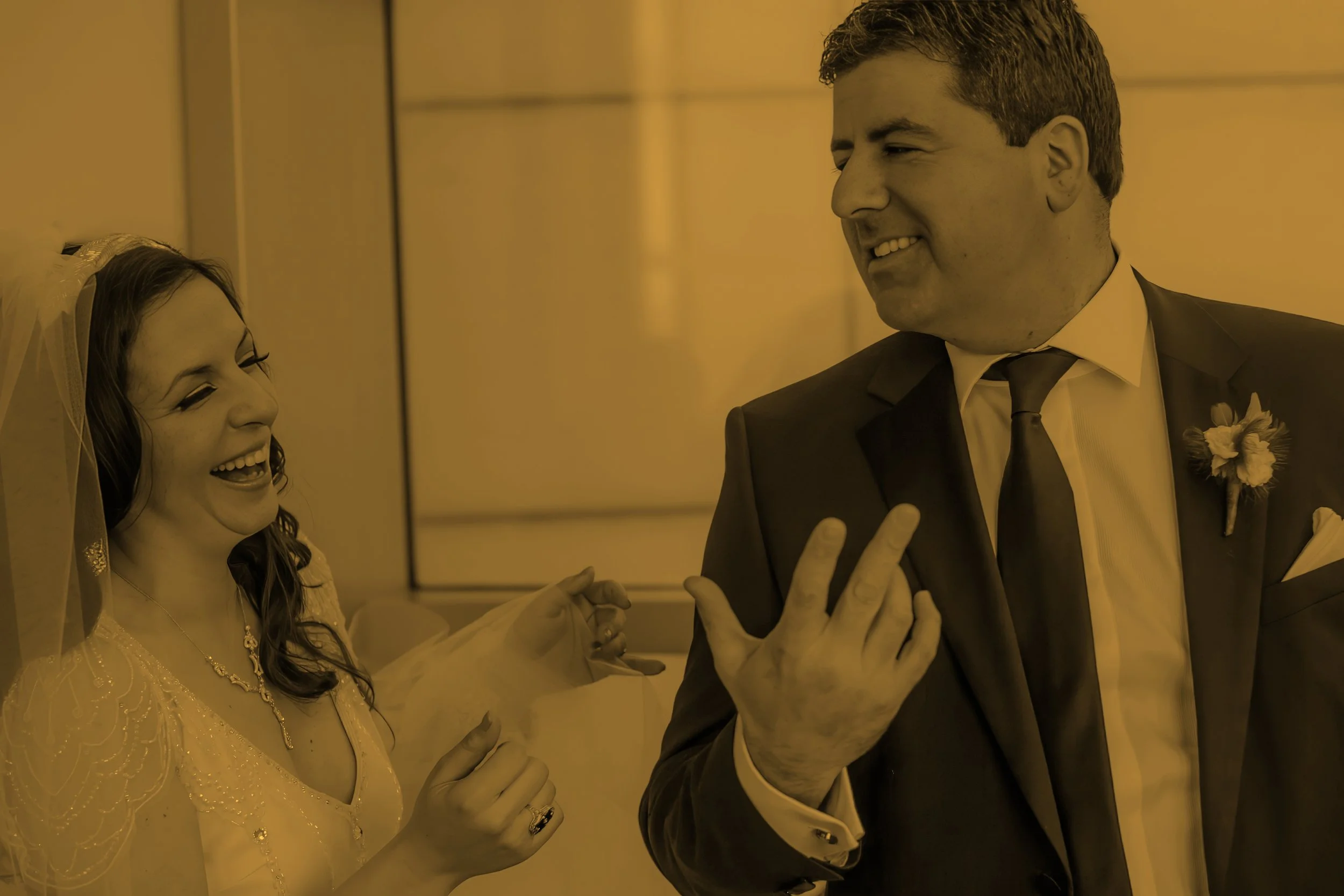 Bride and groom sharing a spontaneous laugh together during their wedding day.