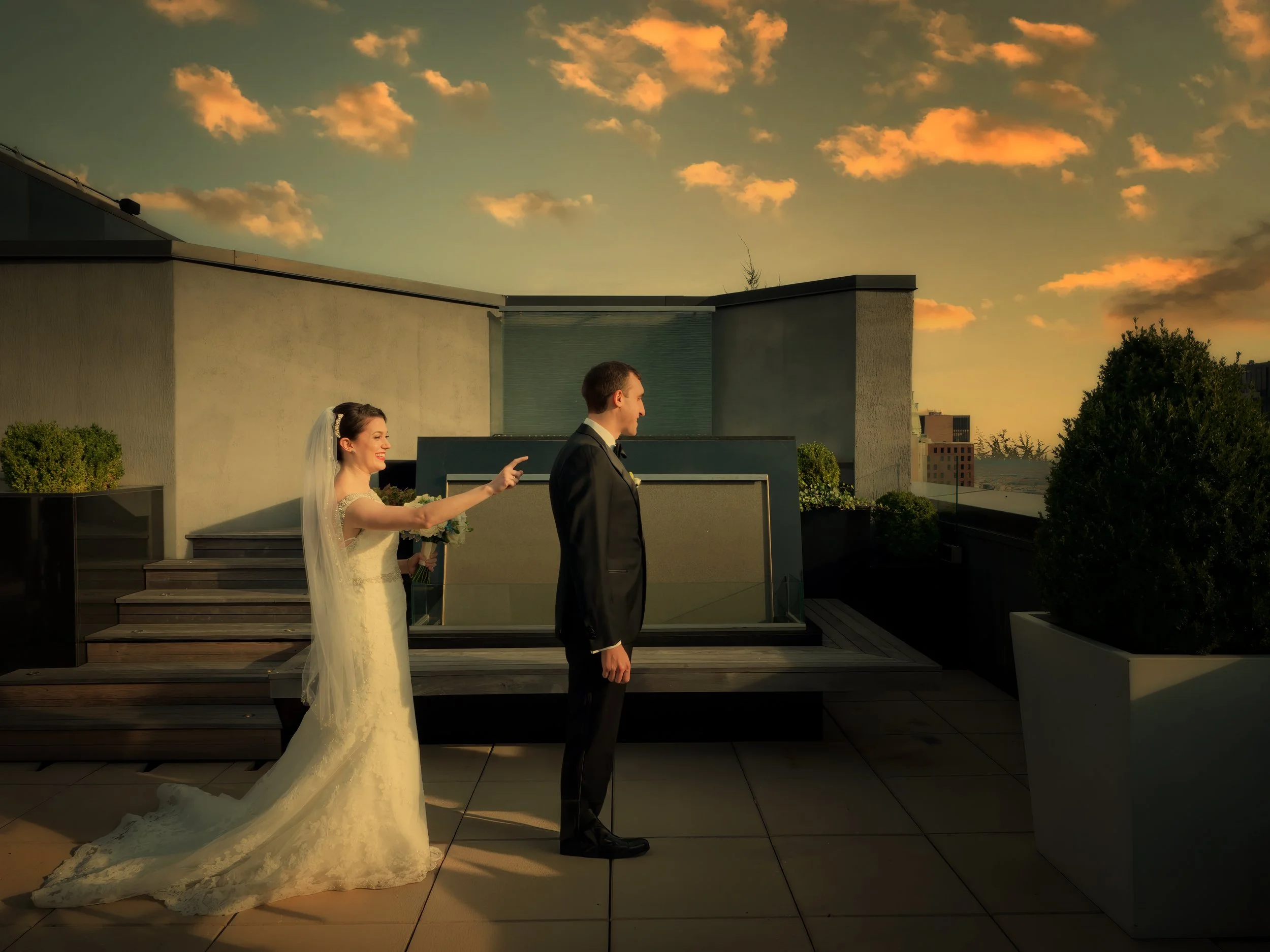 Bride tapping the groom’s shoulder during a first look on the rooftop terrace of the Lotte New York Palace Hotel.
