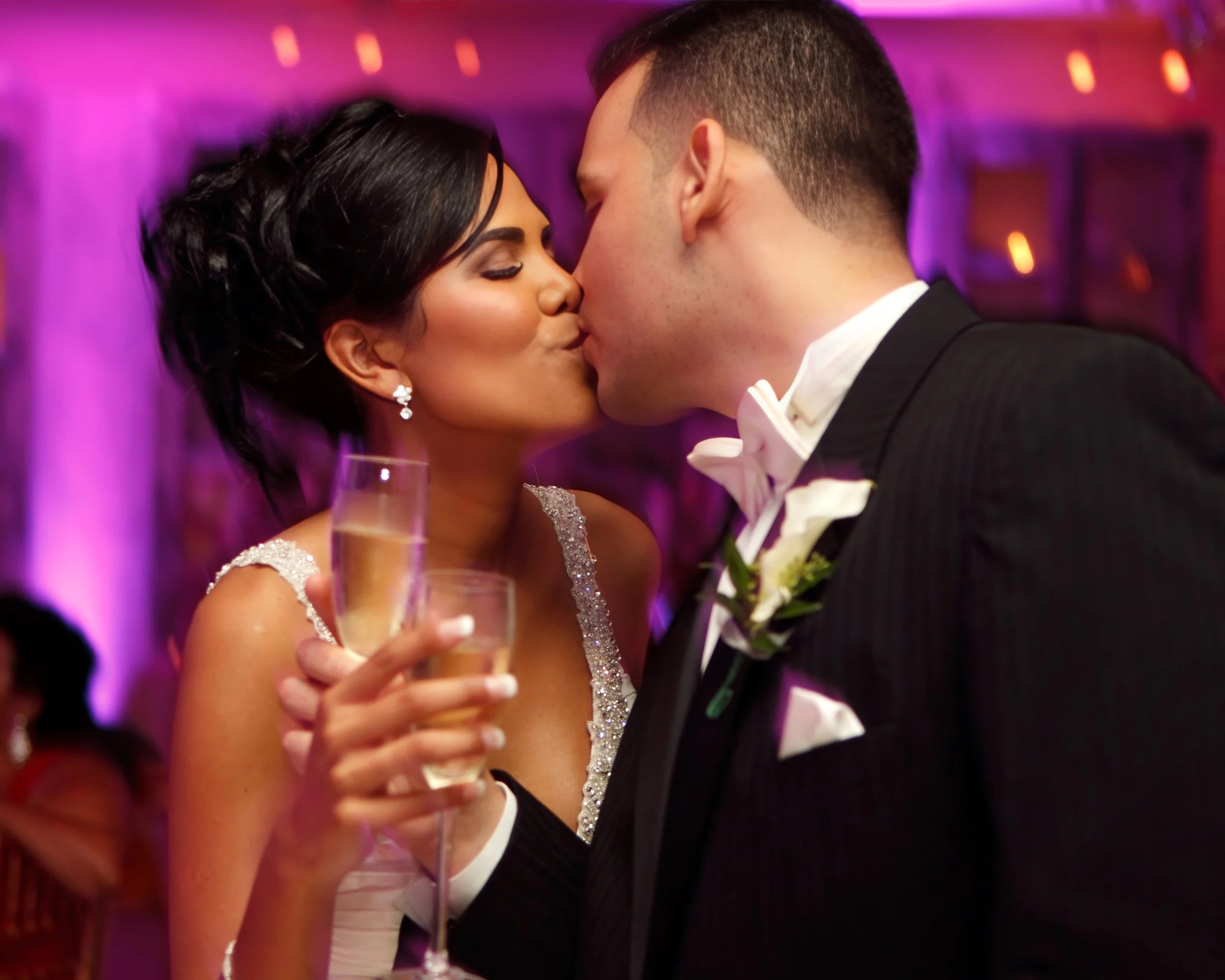Bride and groom share a champagne toast and kiss at their reception at Delamar Greenwich Harbor.